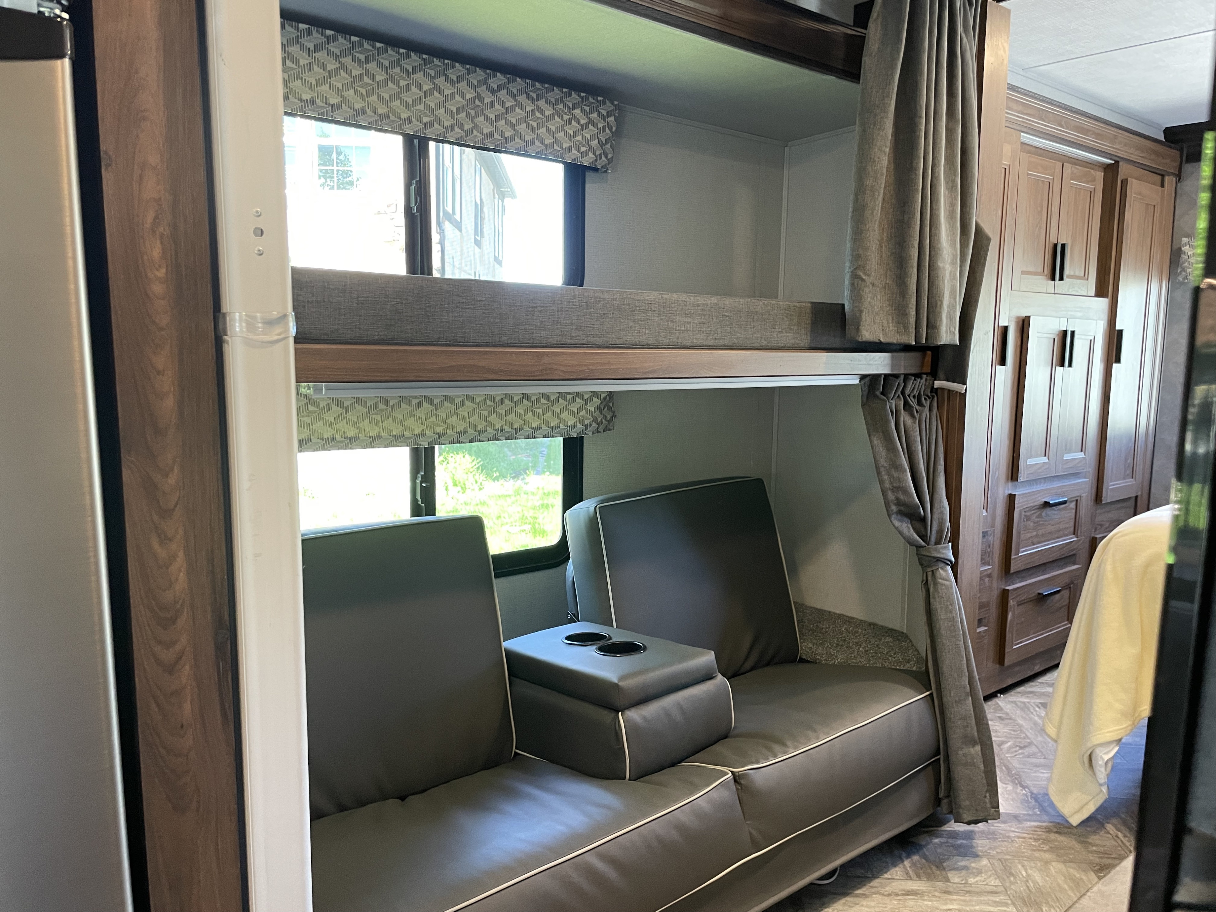 Comfortable RV rental interior with bunk beds, a sofa with cup holders, and storage cabinetry.. Forest River Forester 2022