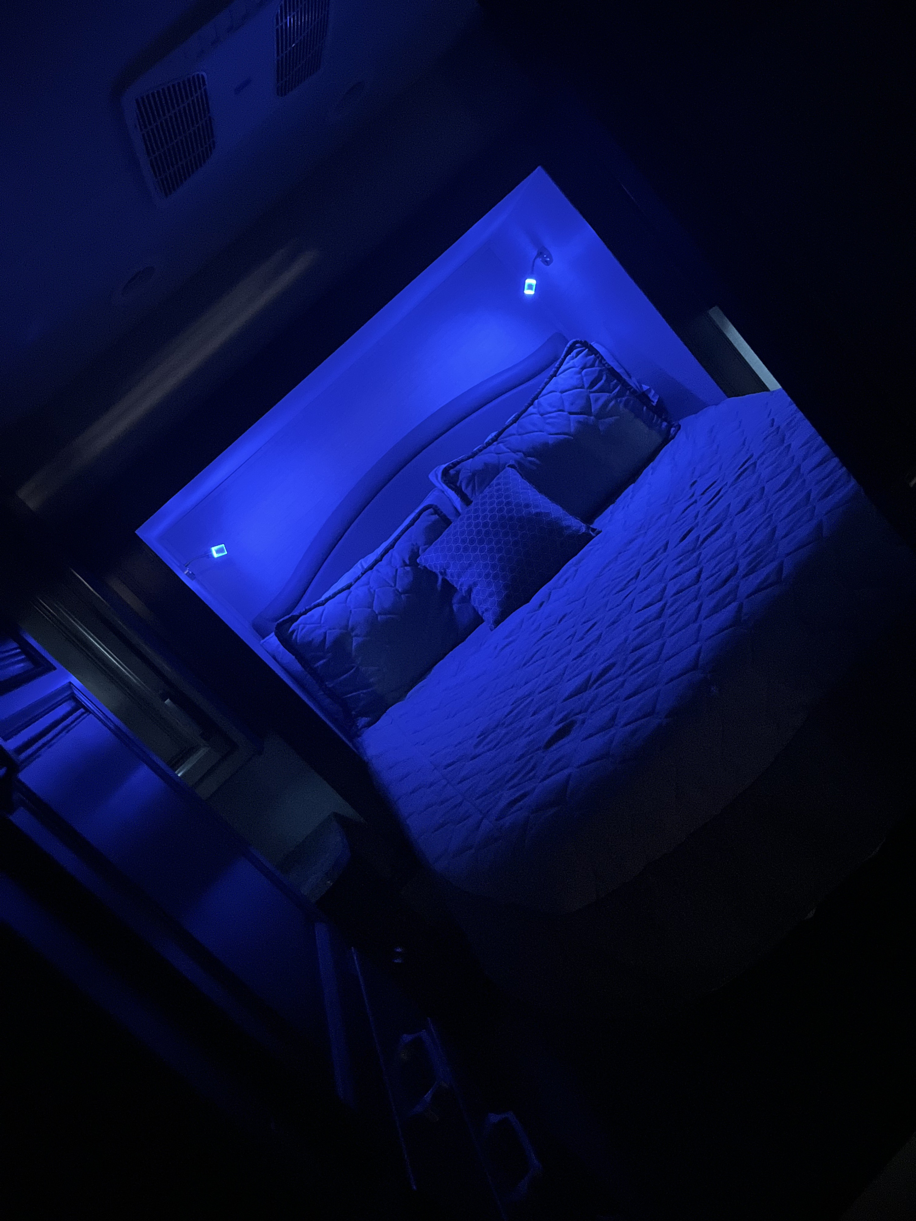 Cozy blue-lit RV rental bedroom: quilted bed, pillows, and ceiling vents. Ideal for a relaxing camper experience.. Jayco Greyhawk 2020