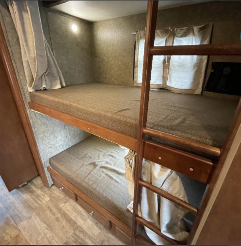RV rental interior featuring comfortable bunk beds, a ladder, and storage drawers. Perfect for family adventures.. Georgetown XL 2015