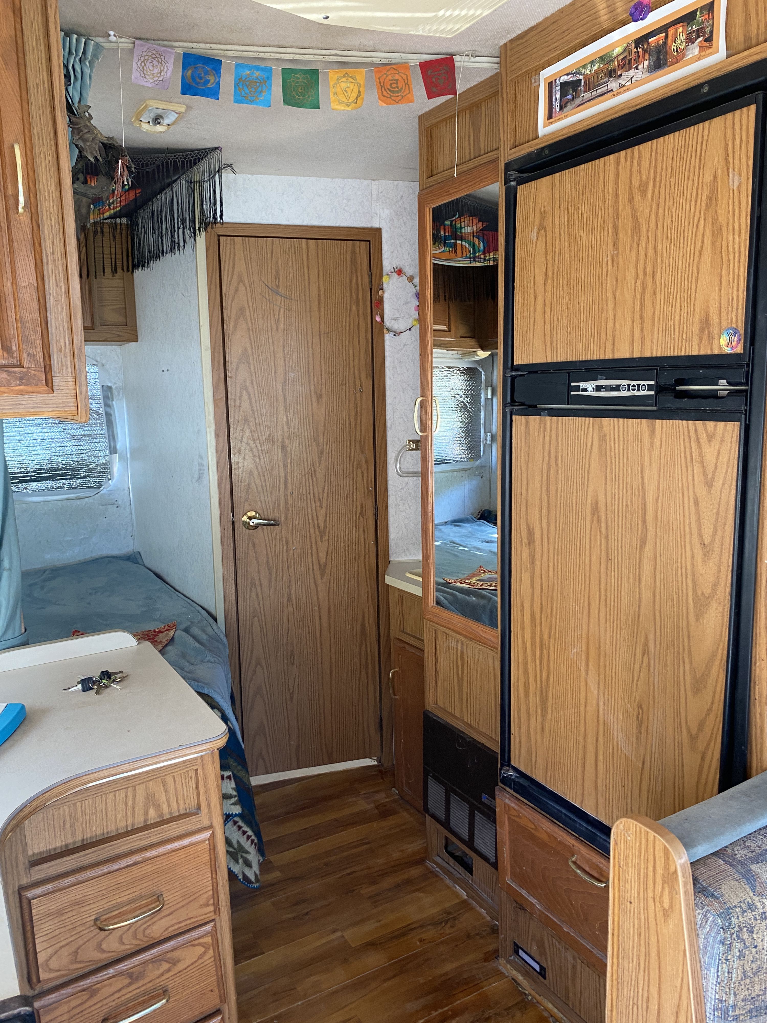 Discovering home on the road in this cozy RV rental, complete with a bed, fridge, and charming decor like prayer flags.. Winnebago Chalet 2000