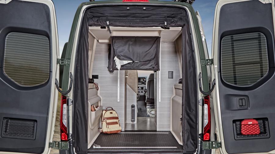 Step inside this RV rental camper van. Rear view with open doors reveals an organized interior, clever storage, & inviting space.. Mercedes Sprinter 2022