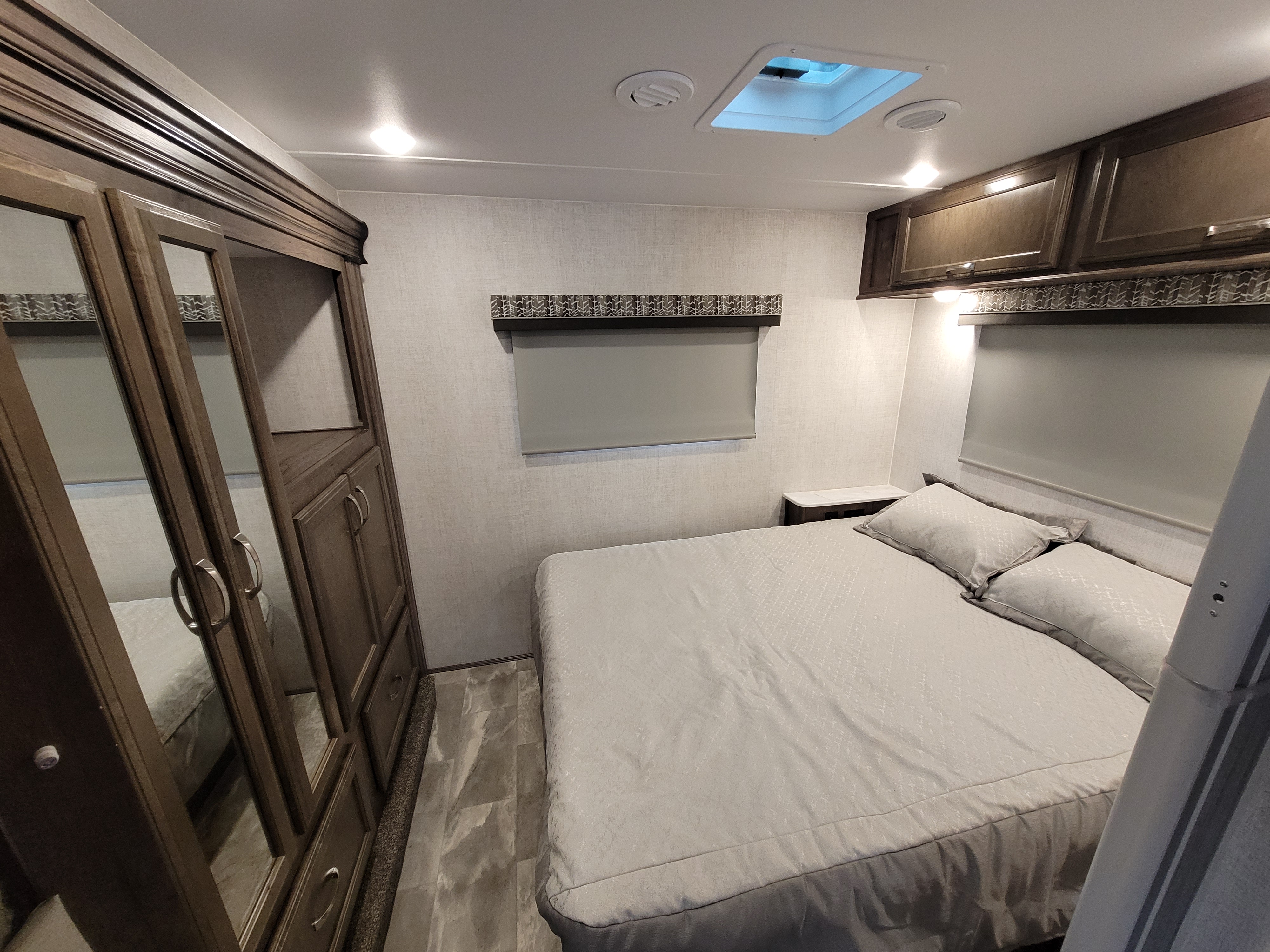 Step into comfort: This RV rental bedroom offers a cozy bed, ample storage, and overhead cabinets for your travels.. Gulf Stream Conquest 2023