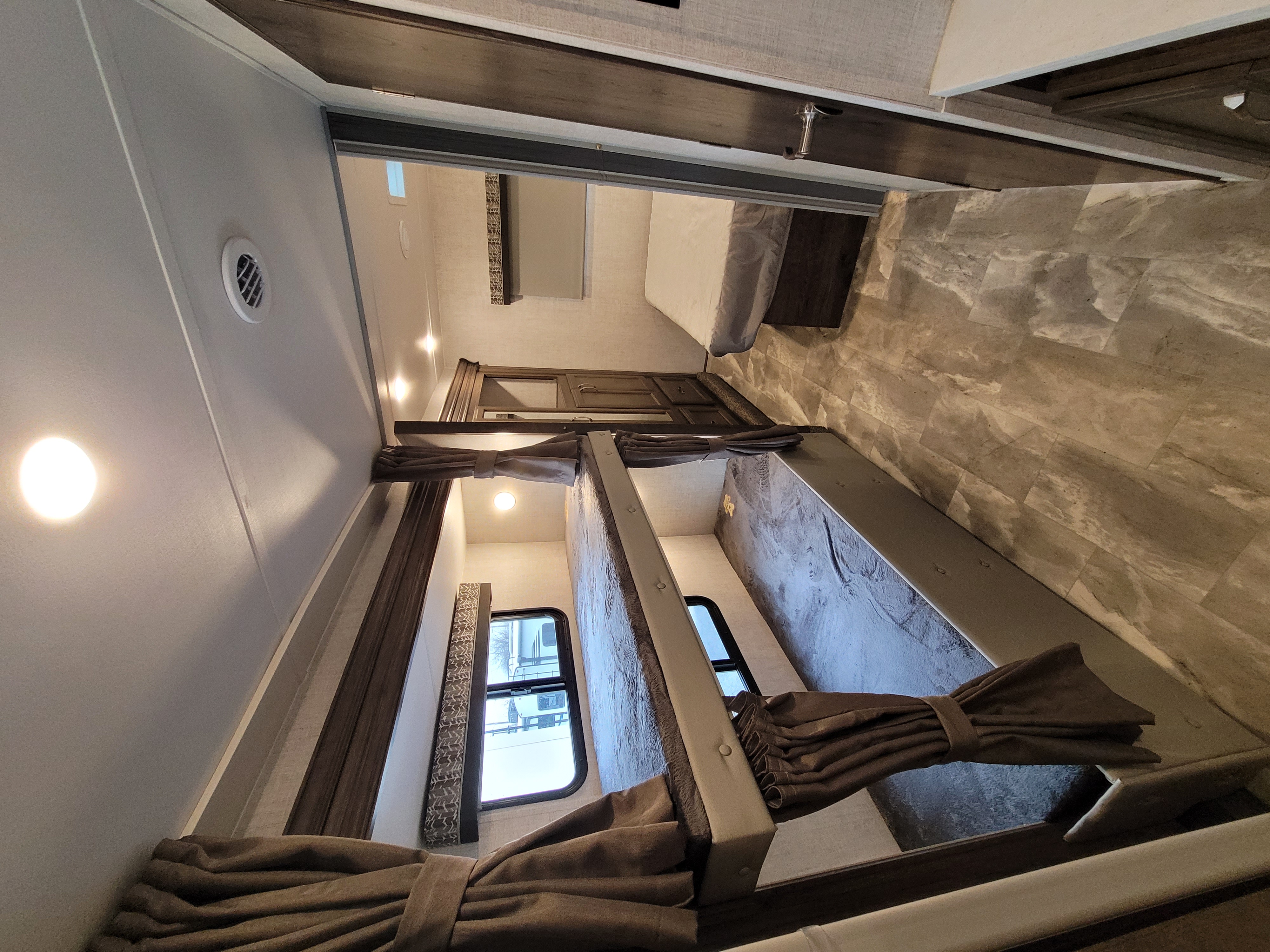 An RV rental interior, showcasing bunk beds with privacy curtains and a view into the master bedroom.. Gulf Stream Conquest 2023