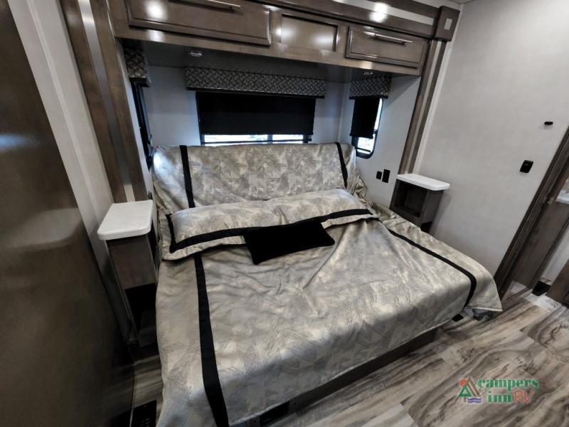 Spacious RV rental bedroom with comfortable bed, nightstands, overhead cabinets, and modern decor.. Ford Germantown 2022