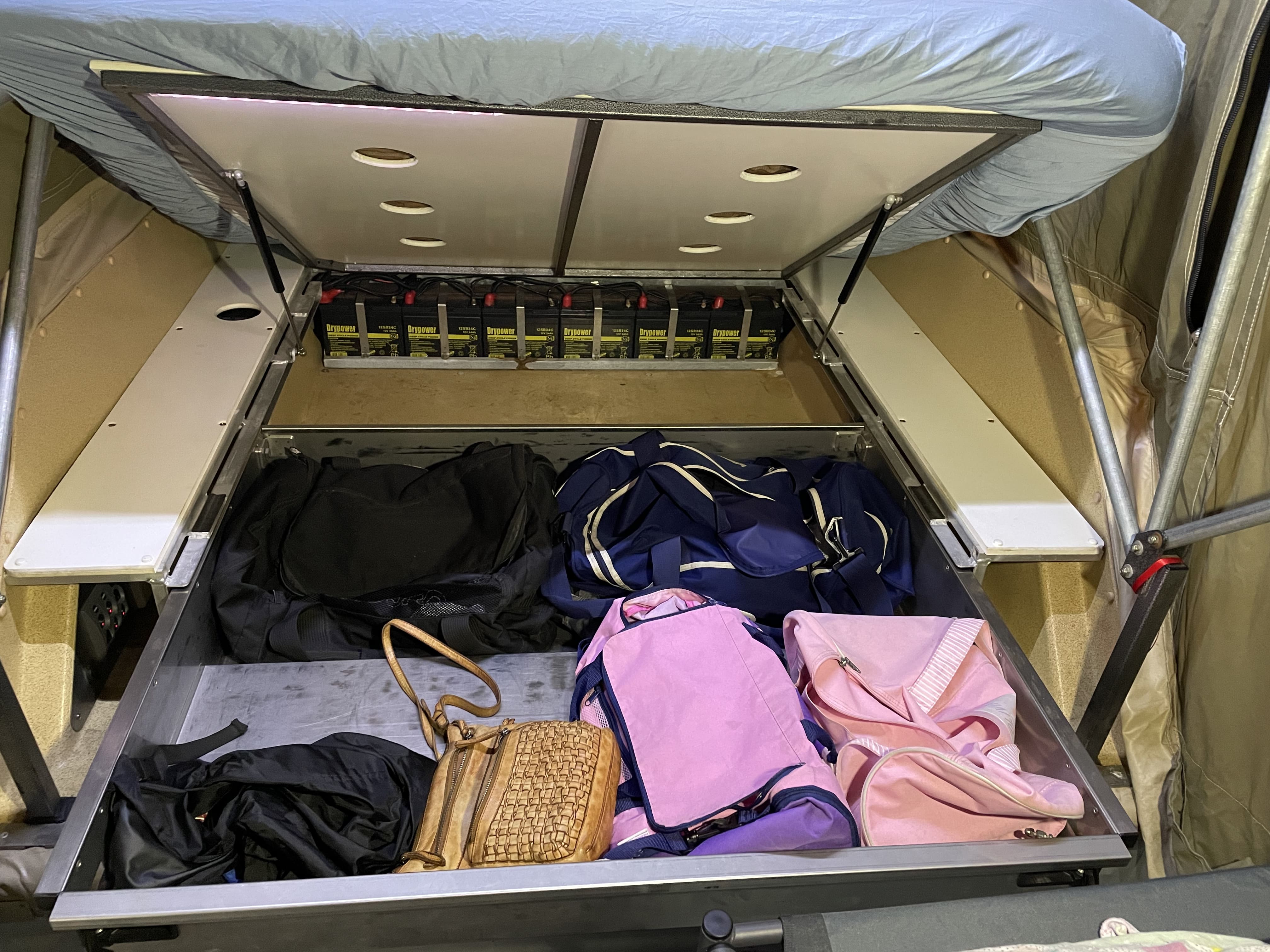 RV rental interior: organized storage drawer with bags, power system with Drypower batteries under bed. Perfect for camping!. Kimberley Kampers Kamper Platinum 2006