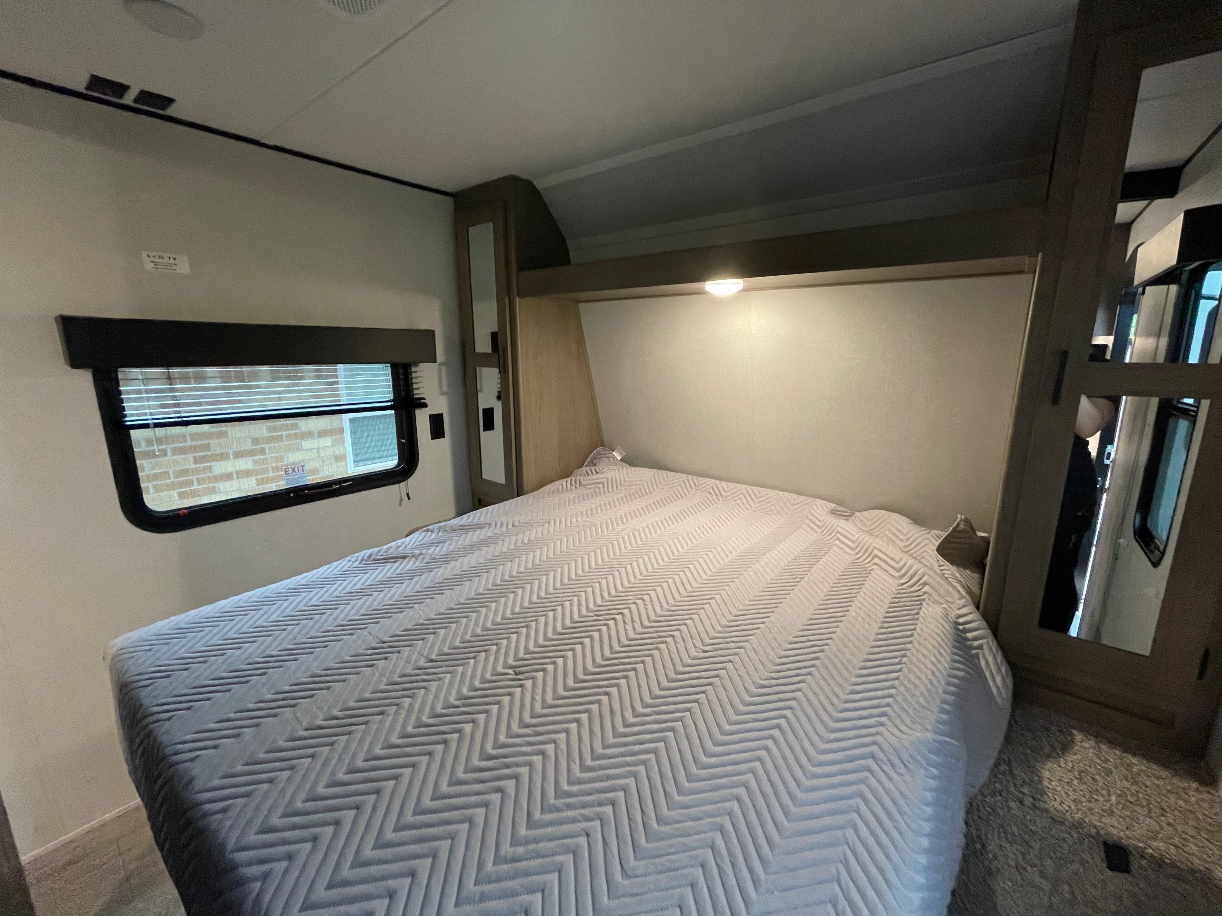 RV rental bedroom: comfy bed, window, power outlets, and built-in cabinetry with mirrors.. Keystone RV Hideout 2021