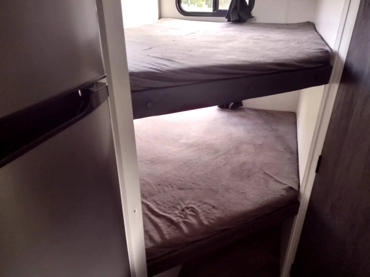 Compact bunk beds and refrigerator in an RV rental. Cozy sleeping for travel.. Forest River Wildwood FSX 2022