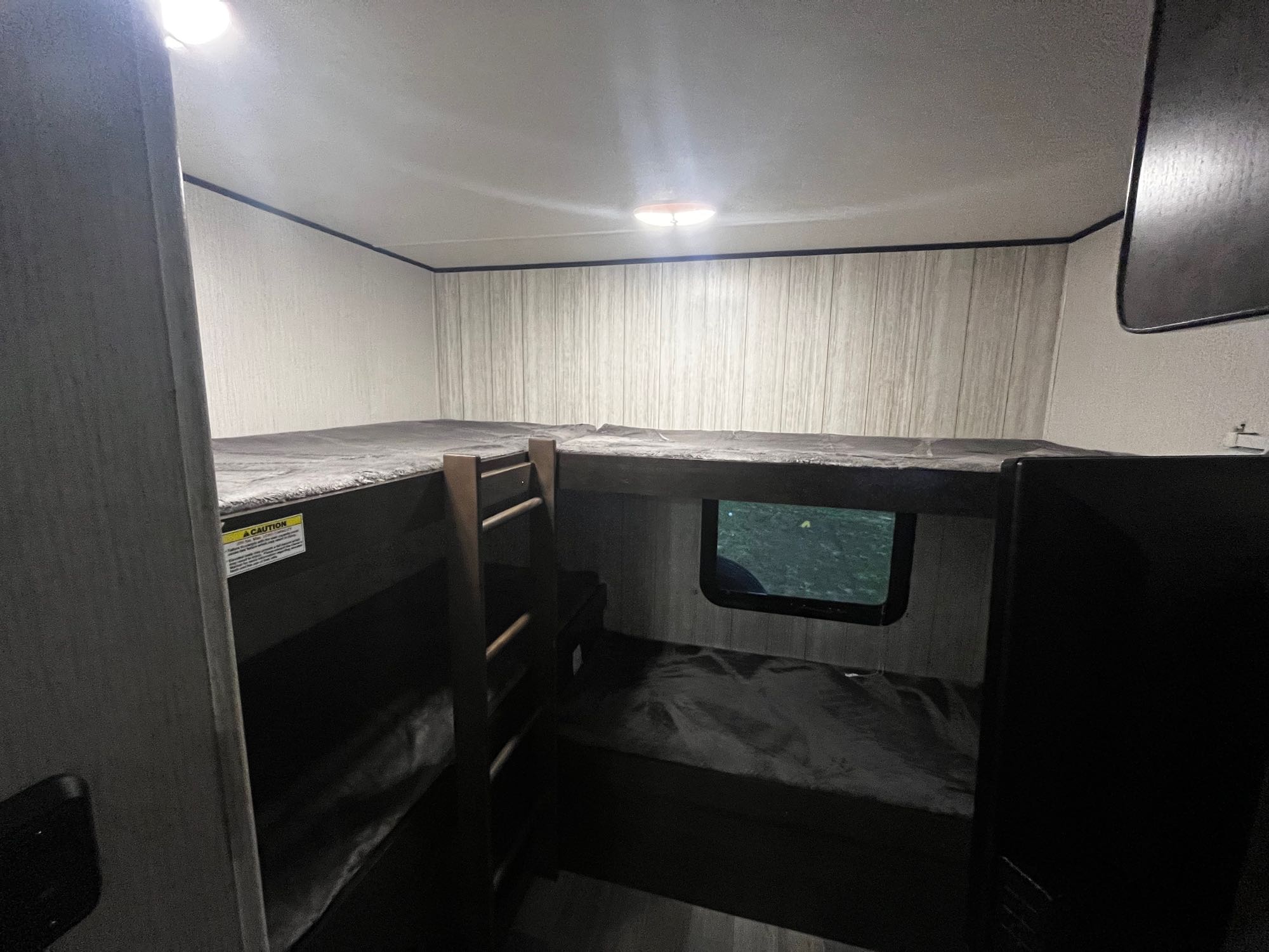 RV rental interior: Comfortable dark bunk beds (two upper, two lower), a window, and ceiling lights.. Heartland RVs Pioneer 2020