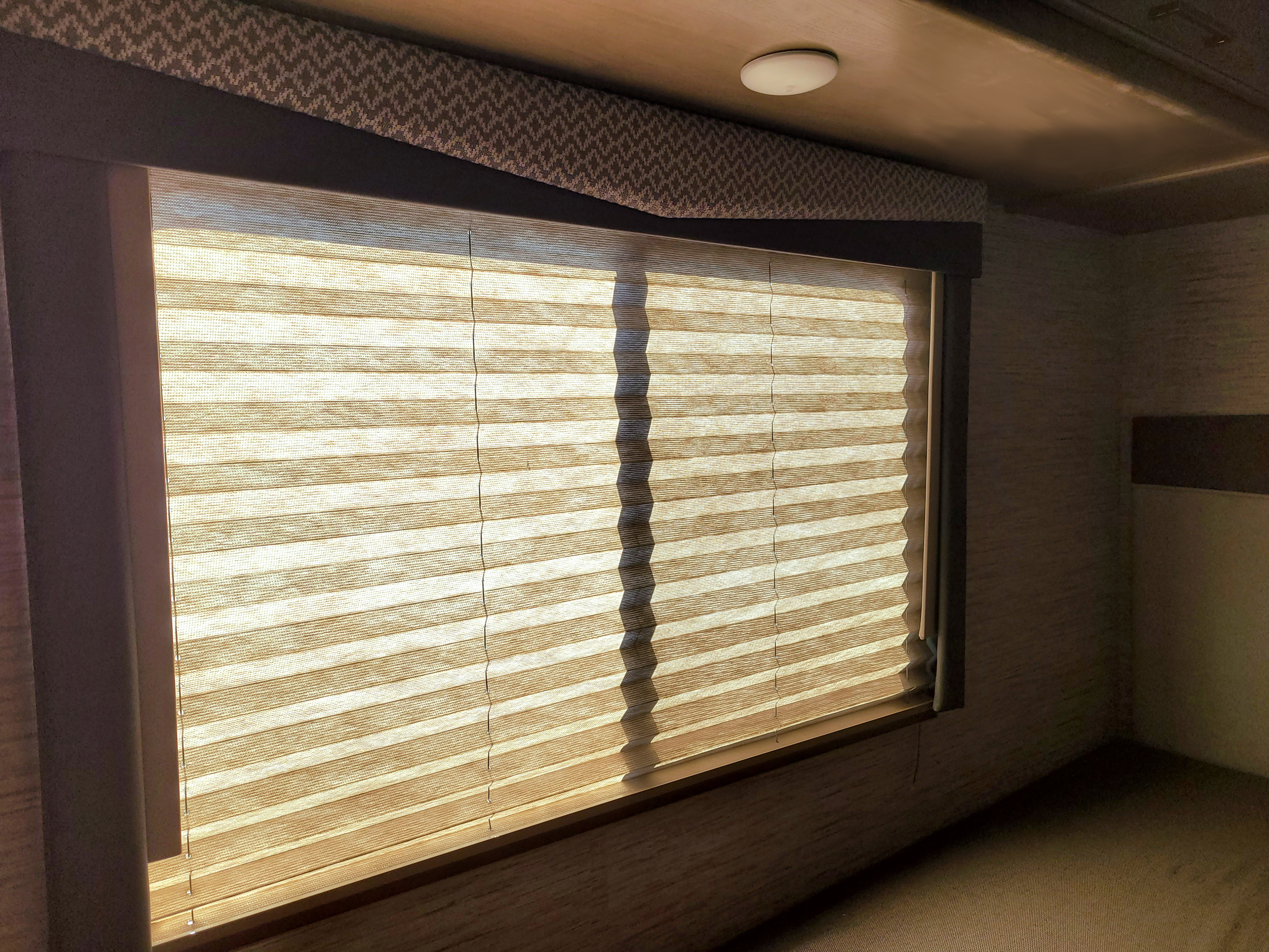 RV rental interior featuring a window with light-filtering pleated shades and decorative valance, providing privacy.. Thor Motor Coach Four Winds 2021