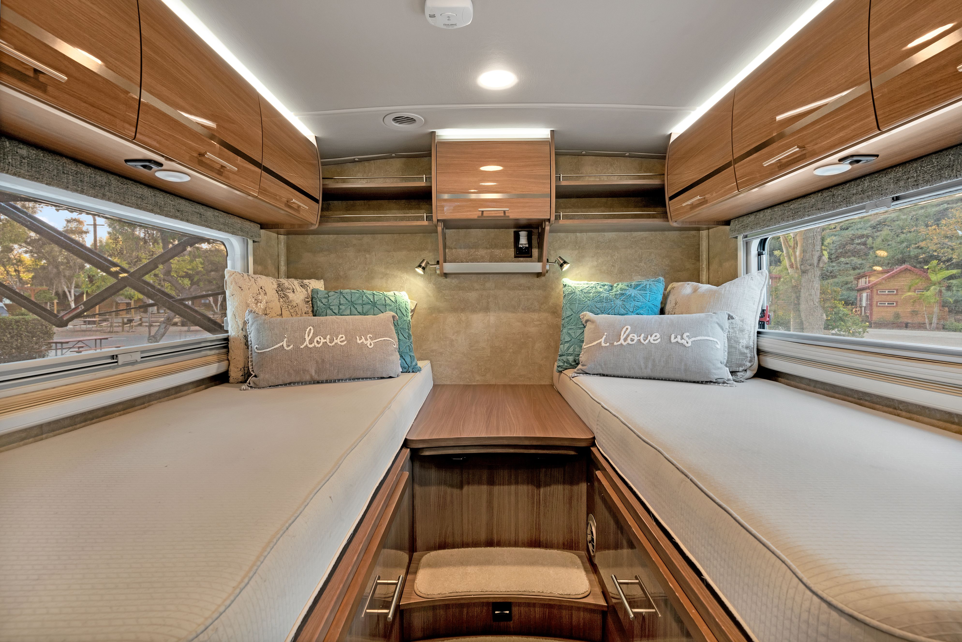 Cozy RV rental interior with two beds, overhead storage, and scenic windows, perfect for your next travel adventure.. Winnebago Via 2015