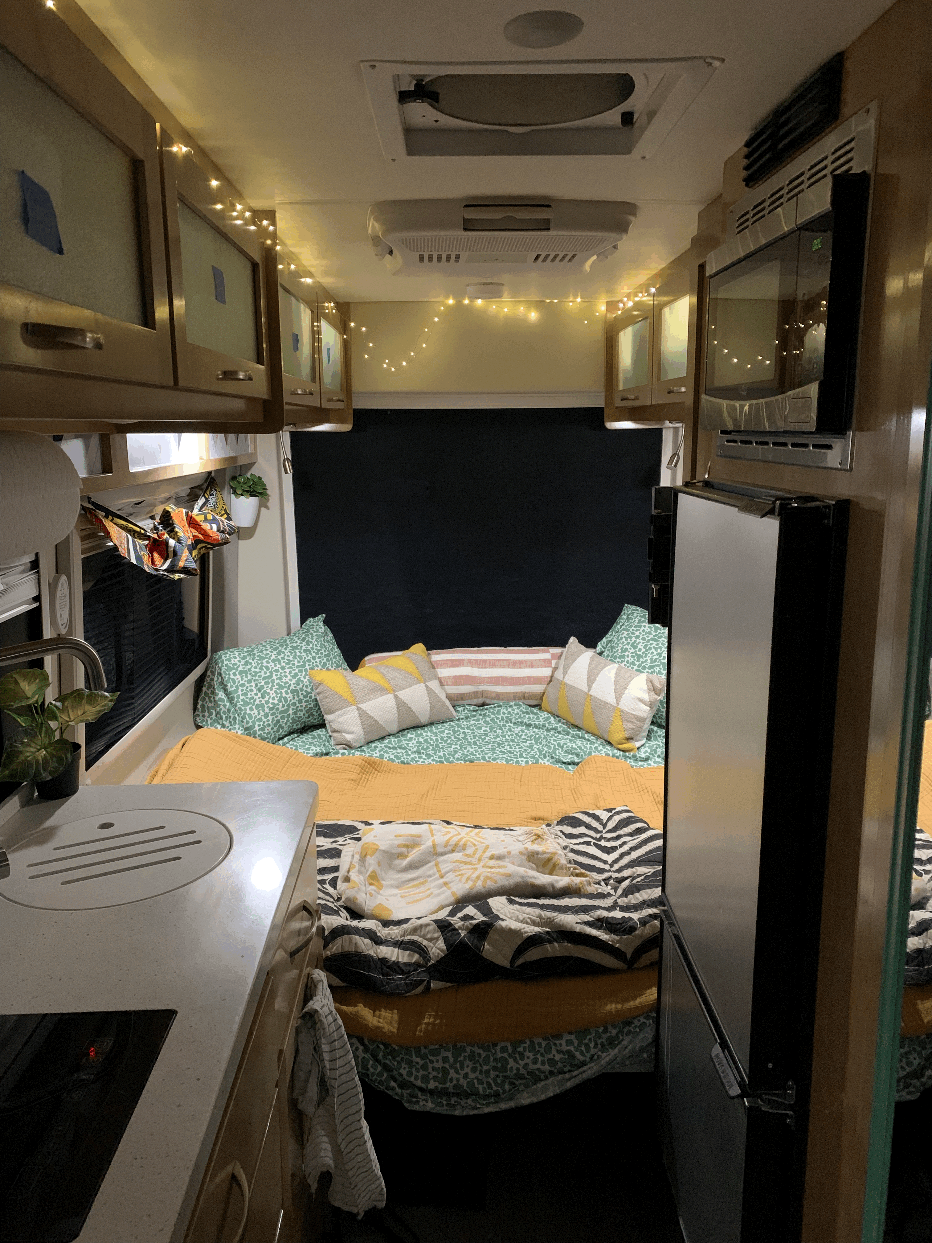 Experience cozy compact living in this rv rental. Features a comfy bed, kitchenette, and amenities, lit by string lights.. Forest River Coachmen Beyond 2020