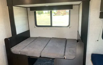 Cozy sleeping area in an RV rental, featuring a convertible bunk bed with cushions and window for comfy travel.. Jayco Jay Flight SLX Baja Edition 2022