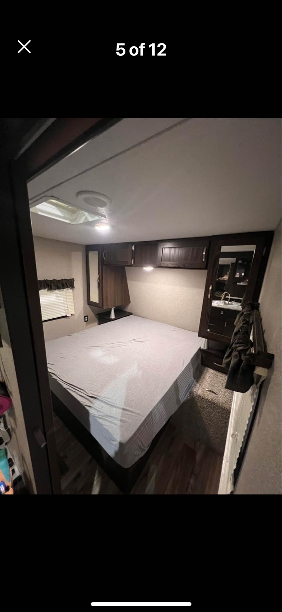RV rental: Bedroom interior with bed, overhead cabinets, window, and compact vanity area on the right.. Keystone RV Springdale 2019