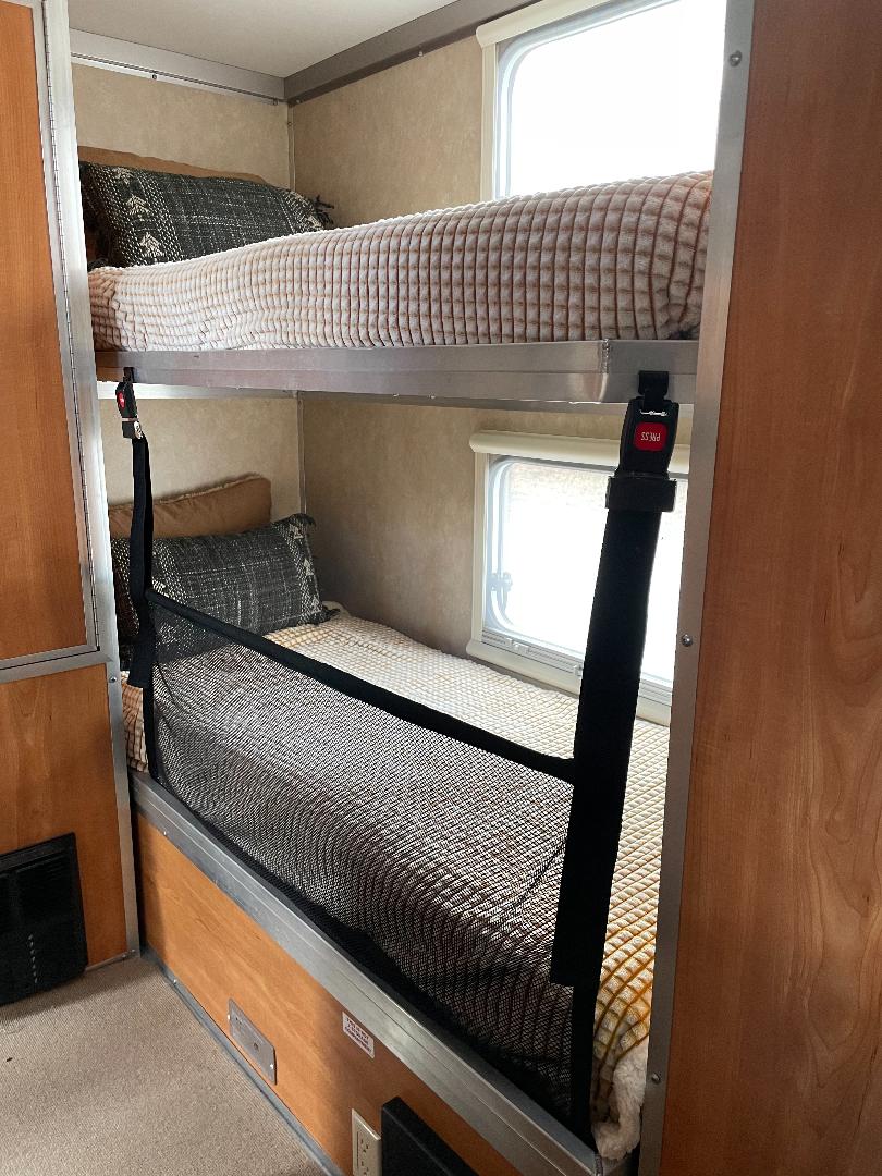 RV rental: Interior view of two bunk beds with bedding and a safety net, typical of a camper or travel trailer.. Camp Lite Camp Lite Trailer 2013