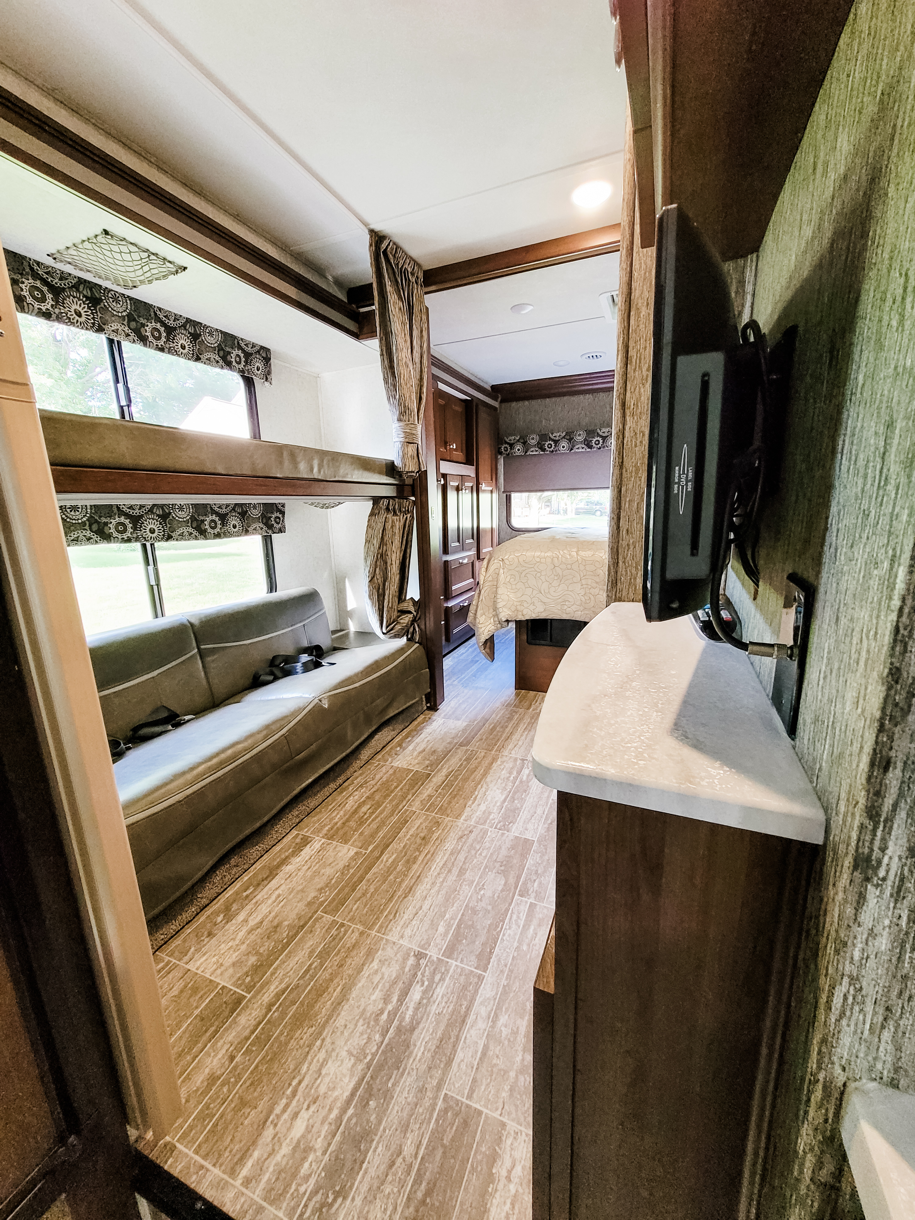 Spacious RV rental interior with bunk beds, sofa, and main bedroom. Perfect for comfortable travel and lodging.. Forest River Sunseeker LE 2018