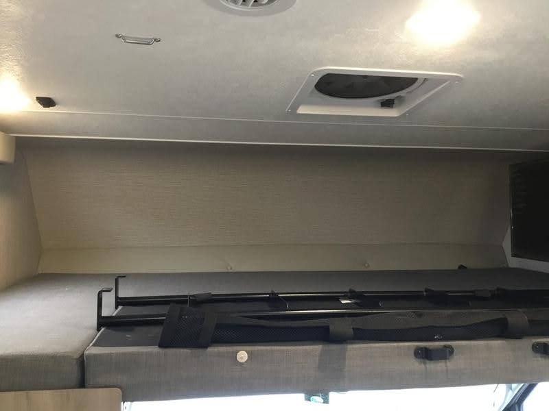 Overhead bunk with safety rail and ceiling details inside an RV rental, featuring a vent and lighting.. Forest River Coachmen Freelander Premier 2022