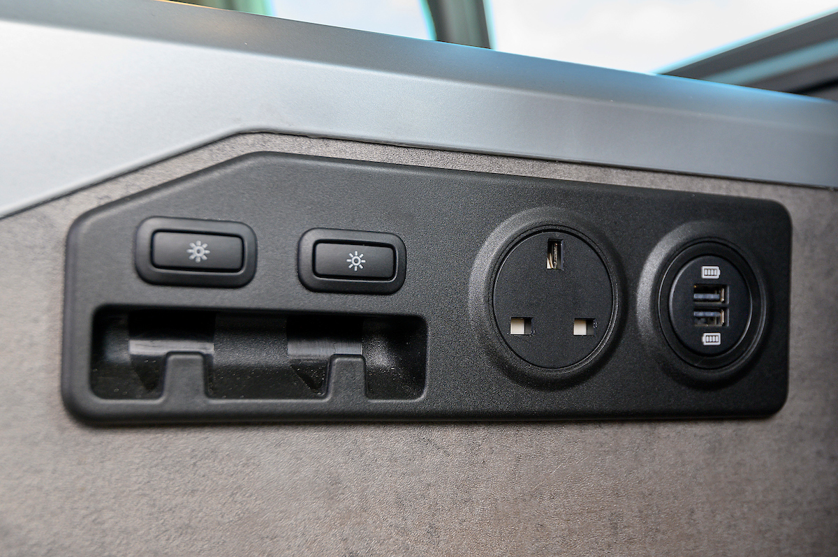 RV rental amenities: UK power socket, dual USB charging ports, and light controls with a storage slot.. Volkswagen California Ocean 2024