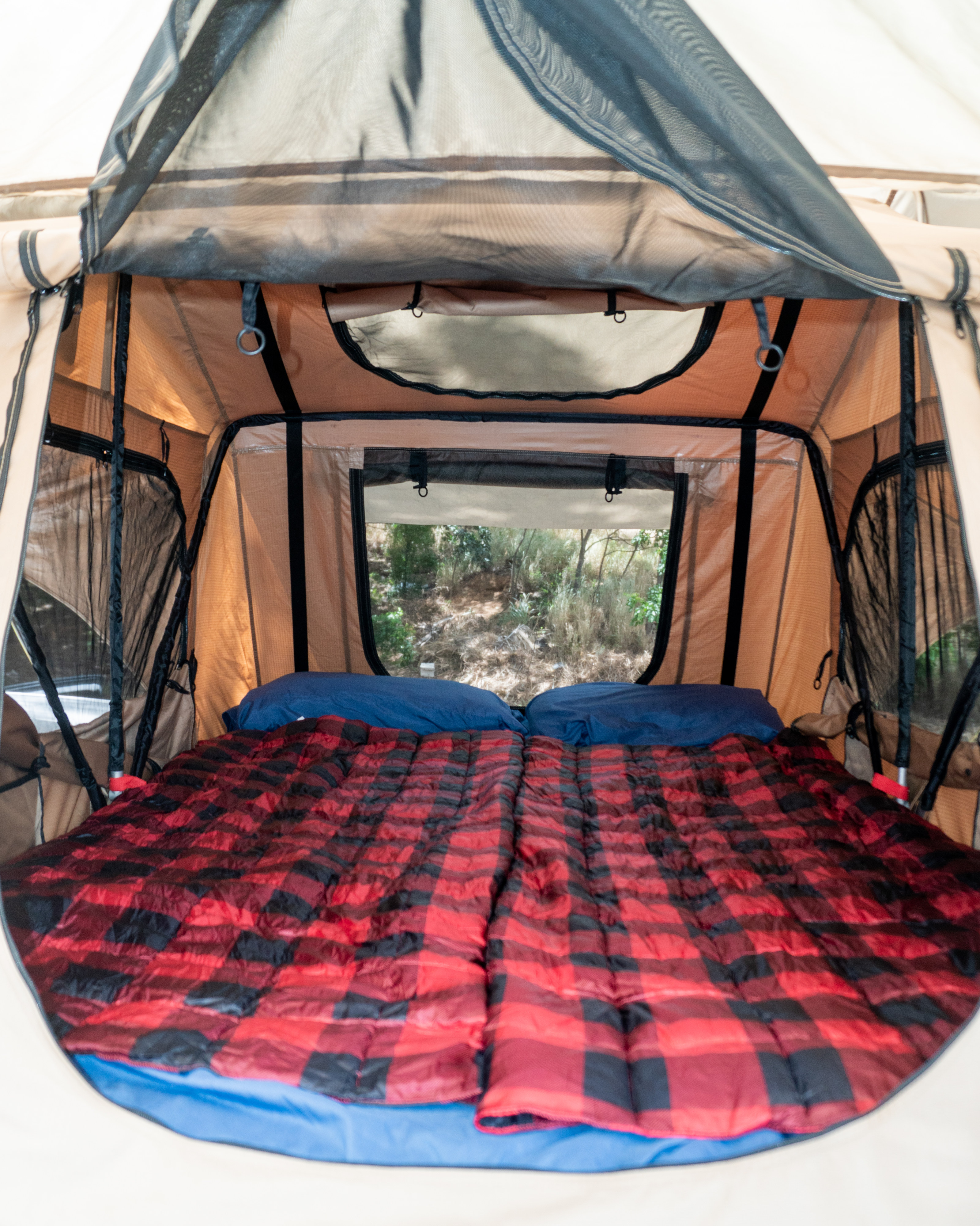 Cozy RV rental tent interior with a comfy bed, plaid bedding, and scenic window views for camping adventures.. Toyota 4Runner 2017