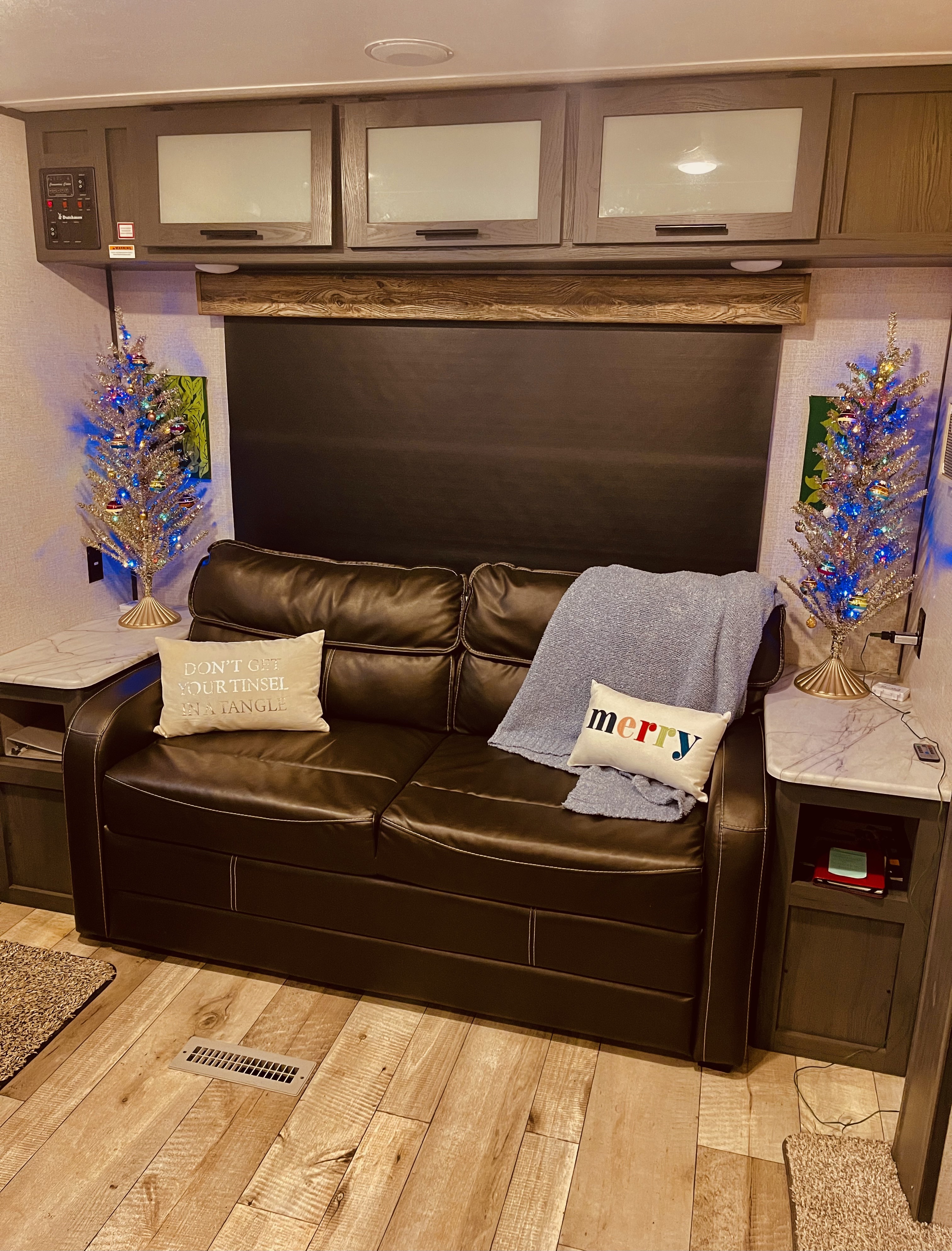 Experience a cozy RV rental: leather sofa, festive decor, and clever storage maximize this compact living space.. Dutchmen Aspen Trail 2022