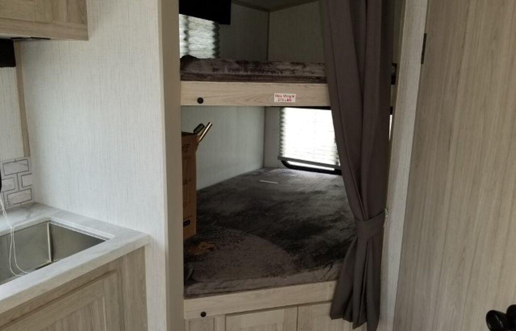 This RV rental features a compact interior with a kitchen sink on the left and sturdy bunk beds on the right. Top bunk has a 275 lbs weight limit.. Cruiser RV Shadow Cruiser 2022