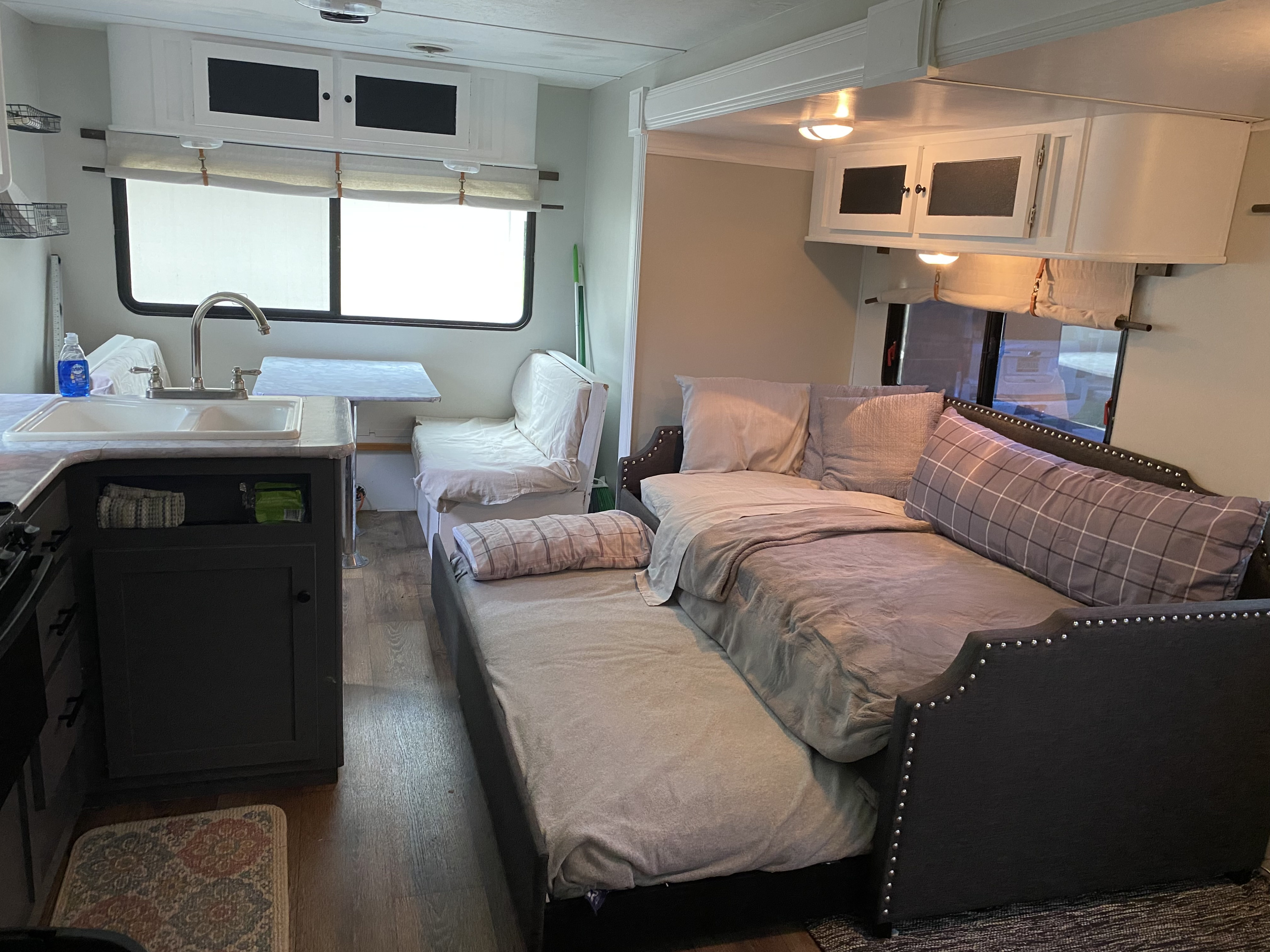 Spacious RV rental interior featuring a modern kitchen, comfortable bed, and dinette area, ideal for travel.. Aspen Trail Aspen Trail Trailer 2015