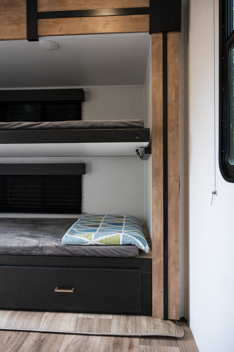 See this RV rental's functional bunk beds with black-out blinds & under-bed storage drawer. A compact sleeping space.. Keystone RV Outback Ultra-Lite 2022