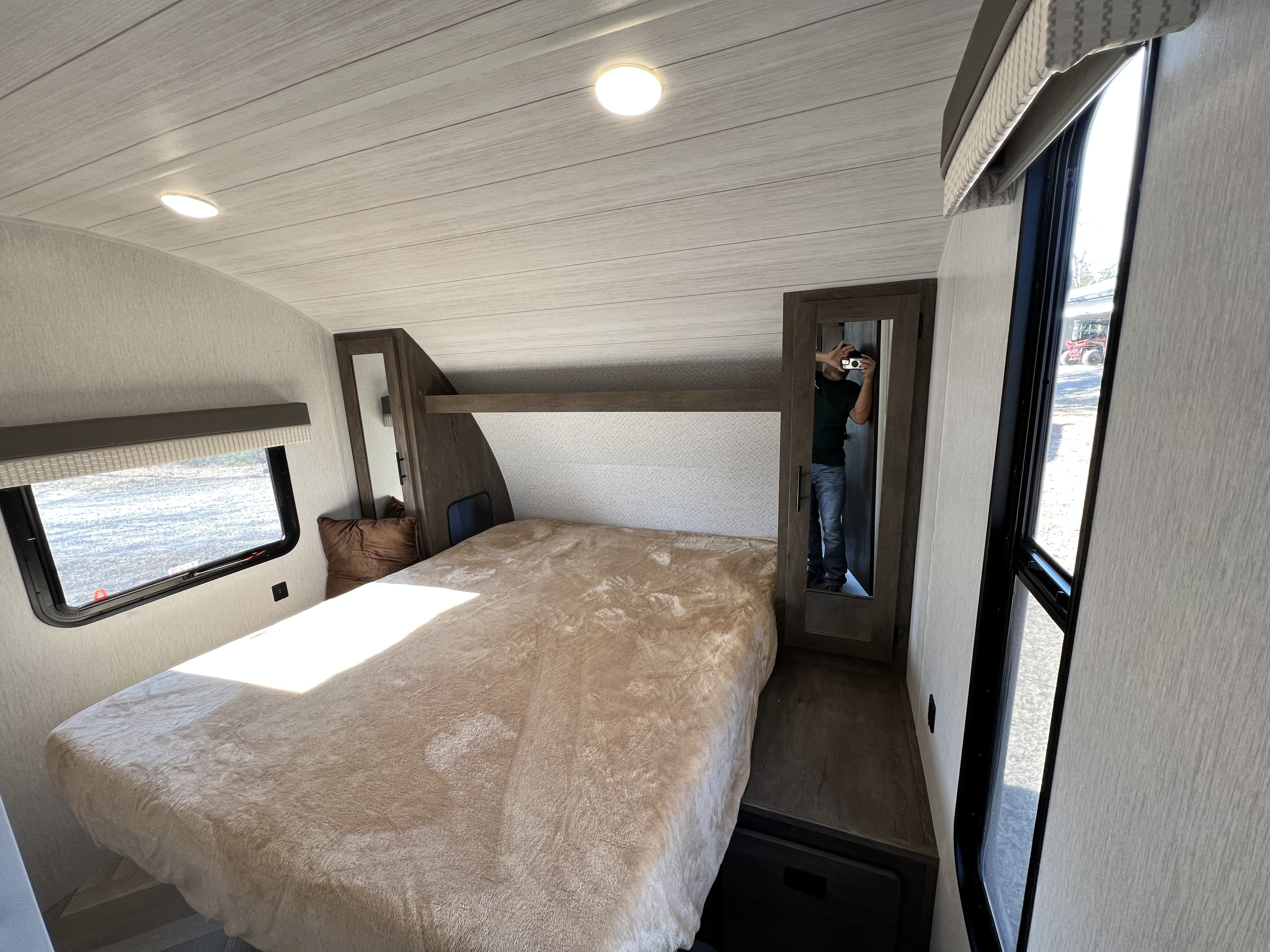 Spacious RV rental bedroom with a cozy bed, large windows, and a mirrored wardrobe, perfect for comfortable travel.. Forest River Wildwood X-Lite 2022