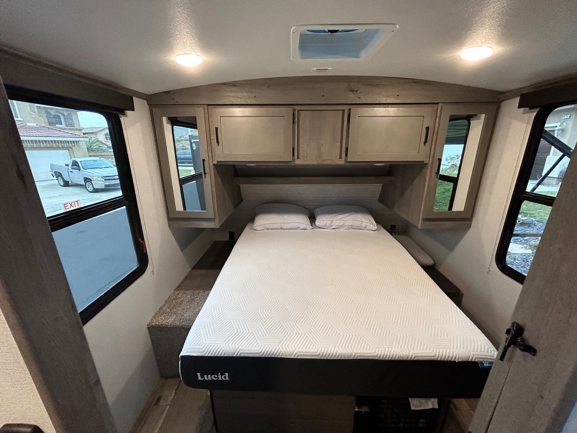 RV rental bedroom: A comfortable bed, overhead cabinets, and bright windows for your travels.. Keystone RV Outback Ultra-Lite 2021