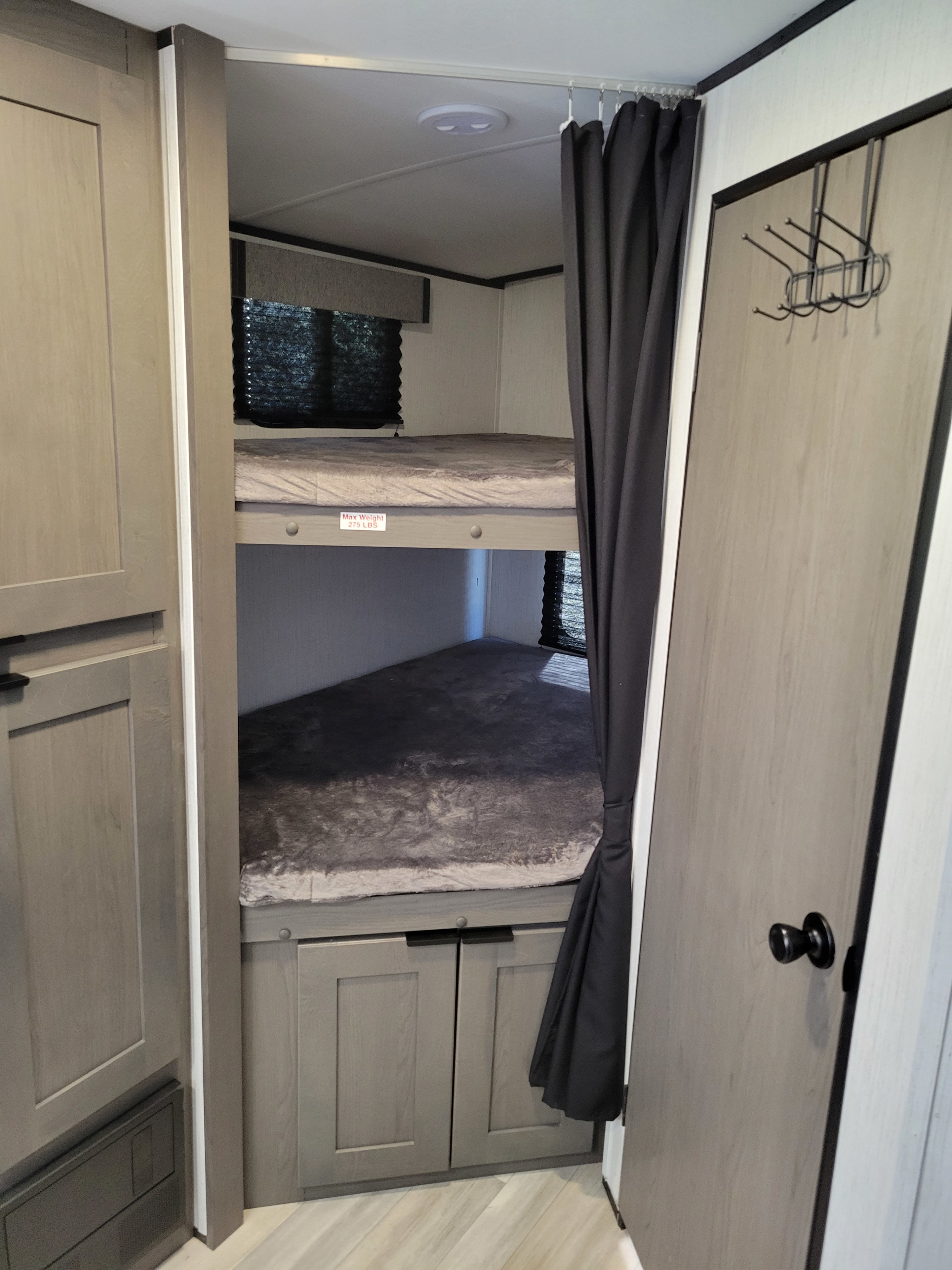 RV rental interior features bunk beds (275 lbs max), privacy curtain, and built-in storage cabinets.. Cruiser RV MPG Ultra Lite 2022