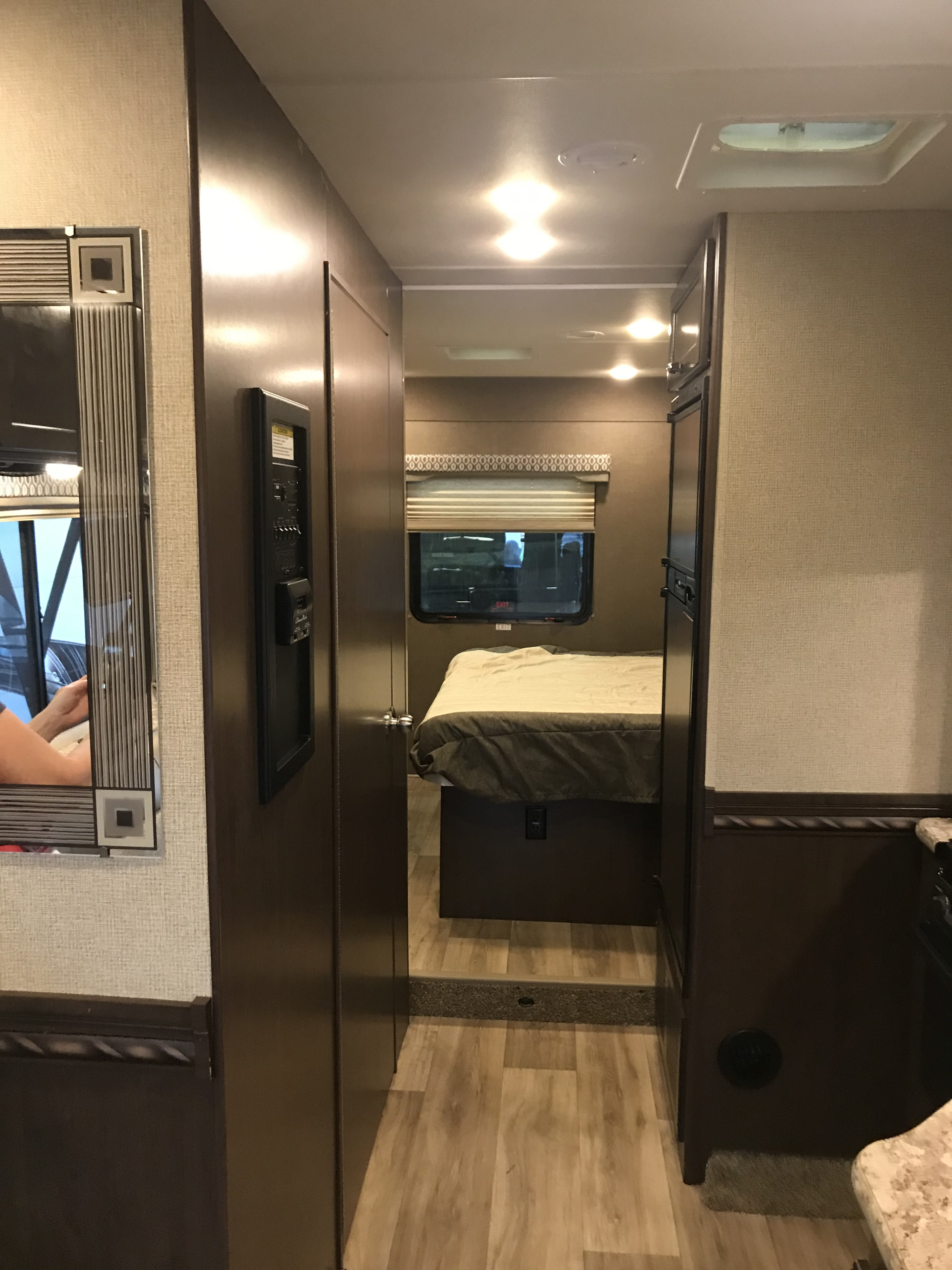 Step into an RV rental! This inviting interior features a hallway leading to a bedroom with a cozy bed and window.. Thor Freedom Elite 2018