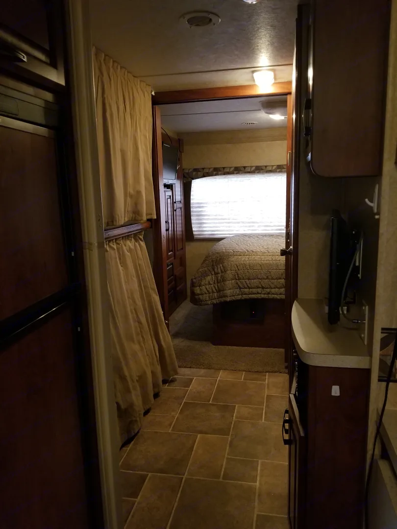 Inside this RV rental: A hallway with bunk beds and a counter leads to a bright, cozy bedroom.. Forest River Sunseeker 2013