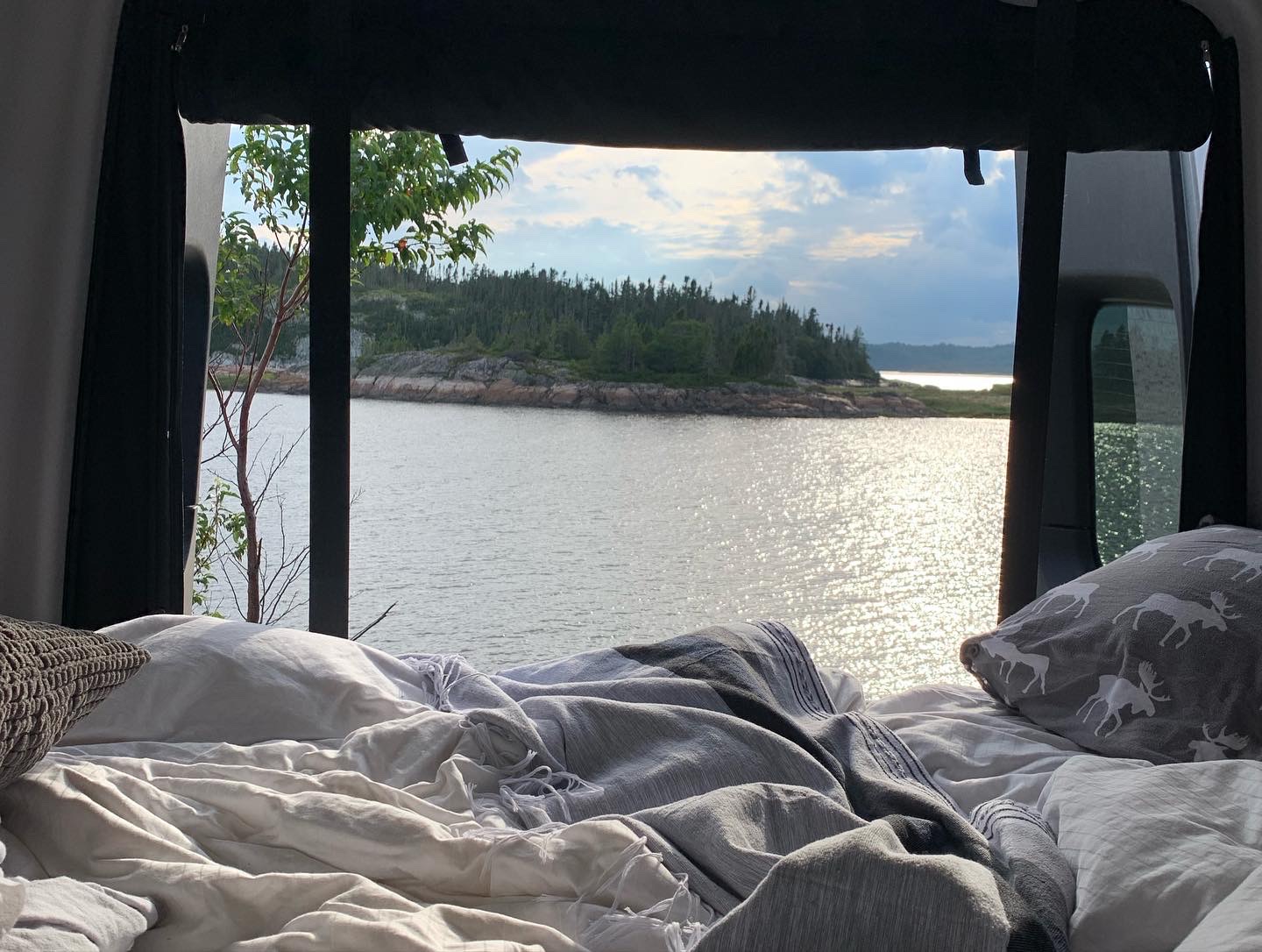Imagine waking up in your RV rental to this stunning lake view from a comfy bed, complete with moose pillow.. Winnebago Revel 2022