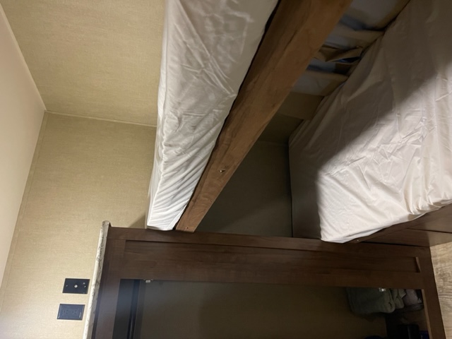 RV rental bunk beds: compact sleeping area with white mattresses and wooden frames, ideal for travel.. Gulf Stream Kingsport 2019