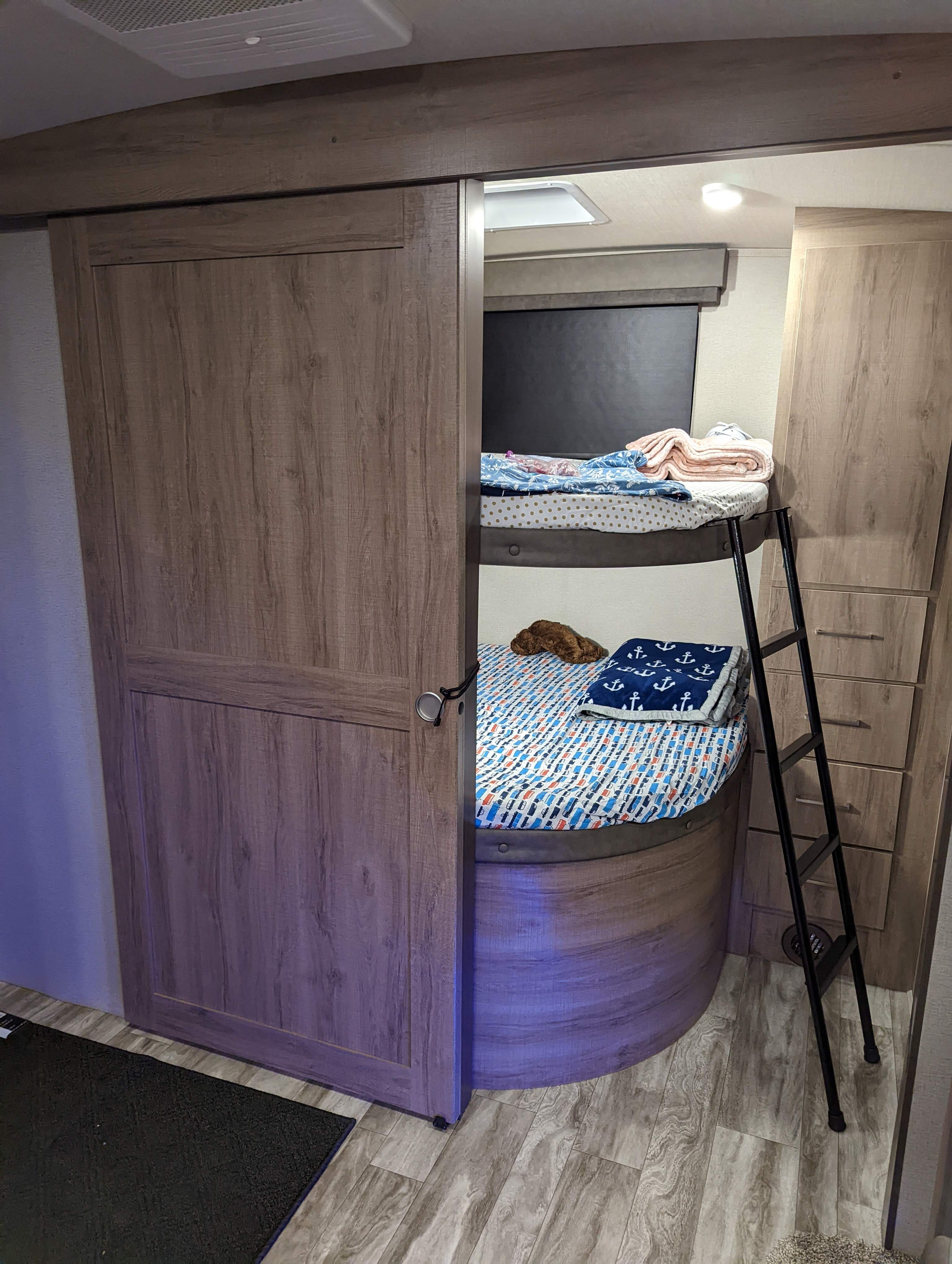 RV rental bunk beds: a compact, cozy sleeping area with ladder & built-in storage for your adventure.. Grand Design Imagine 2022