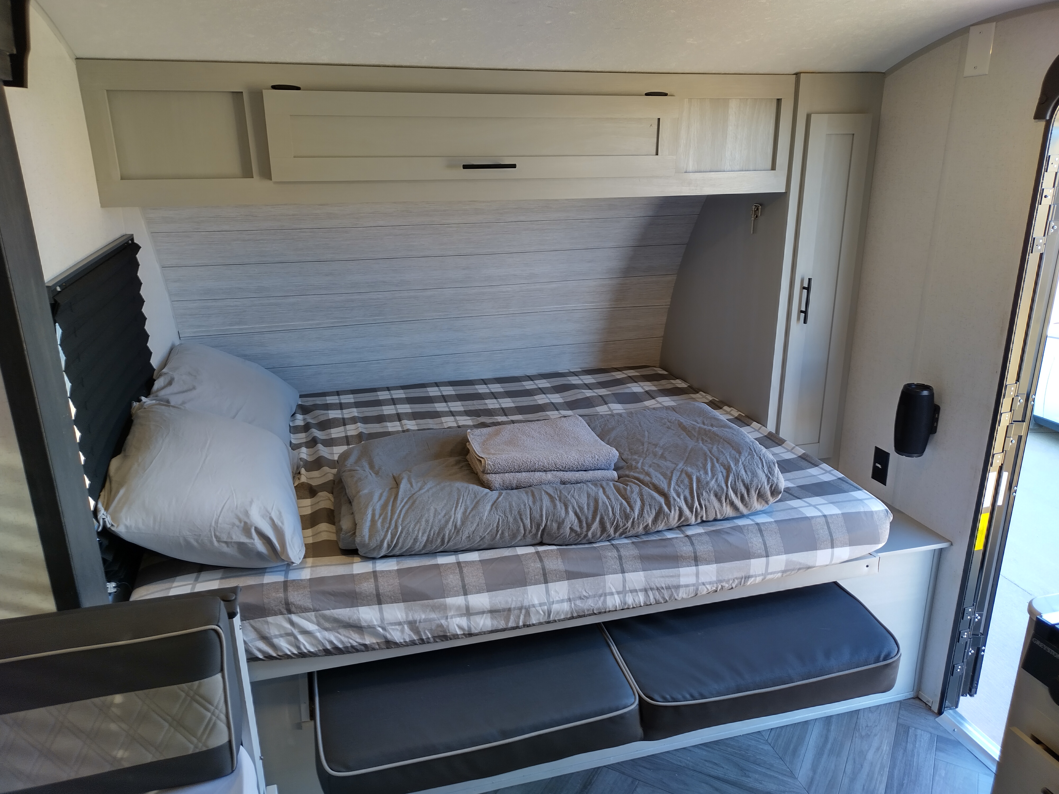 RV rental: Interior view of a cozy bed with plaid bedding, overhead storage, and pull-out seating below.. Forest River Other 2022