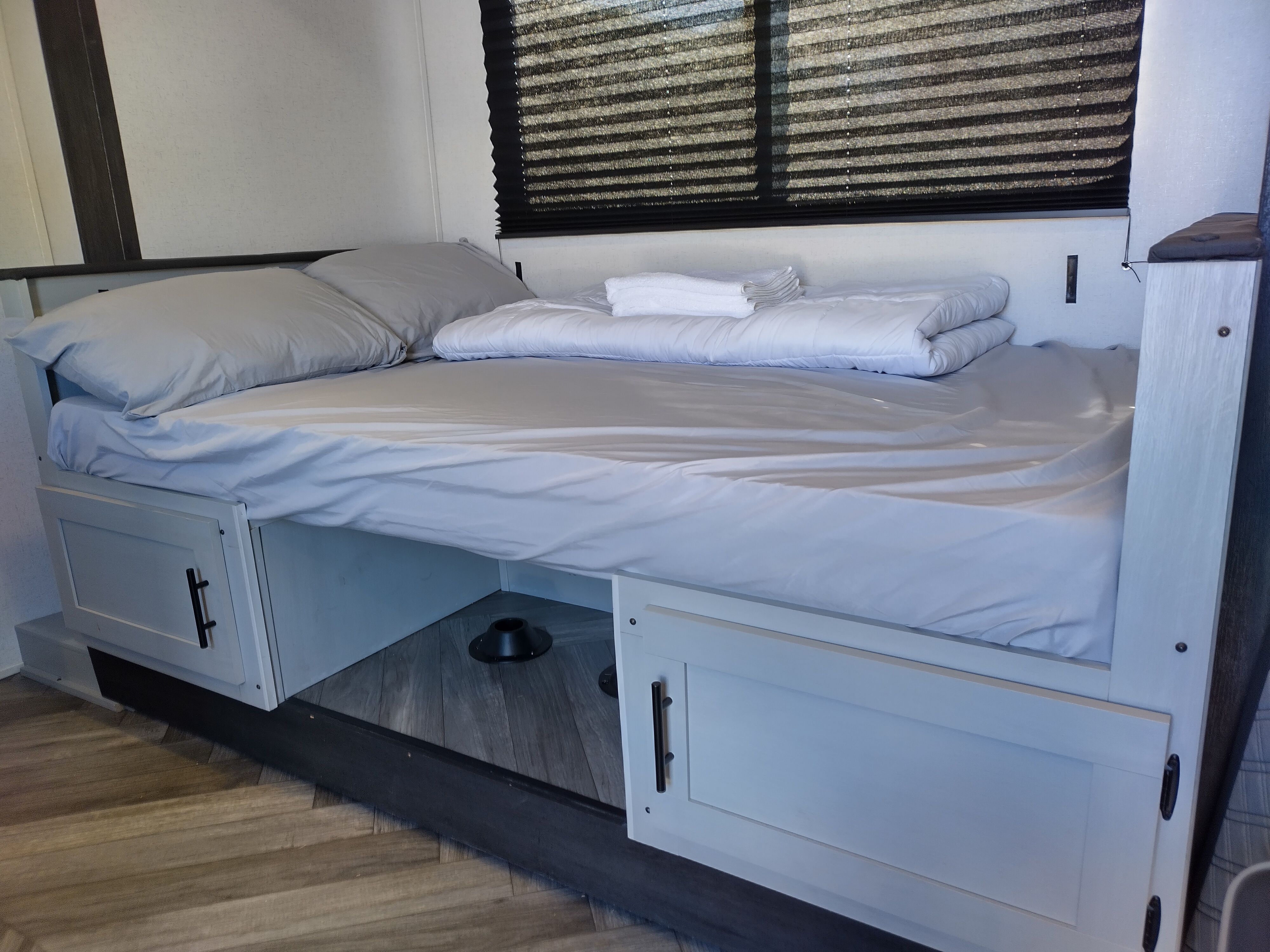 This rv rental features a clean, organized bedroom with a made bed, folded linen, and under-bed storage for efficiency.. Forest River Other 2022