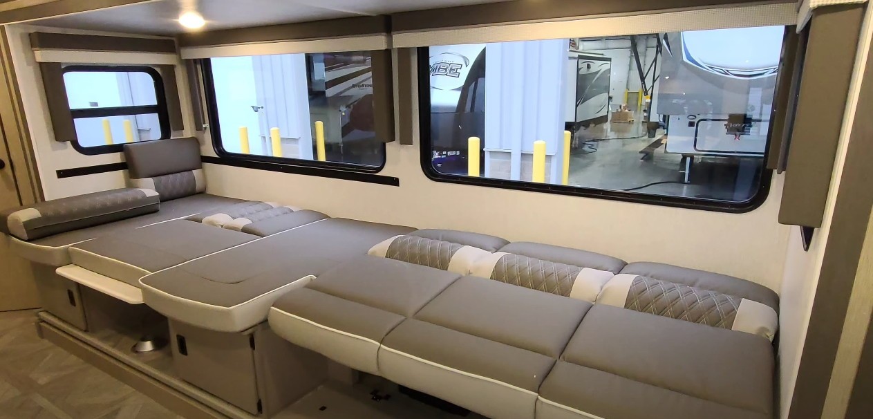 Modern **RV rental** dinette with gray modular cushions, transforming into a comfortable bed.. Forest River Other 2023