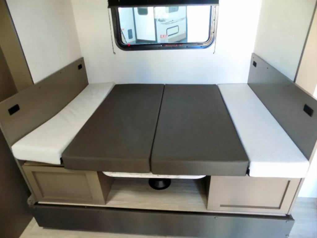 Visually impaired users: This RV rental's dinette converts to a compact bed with comfy cushions & under-bench storage.. KZ Escape 2022