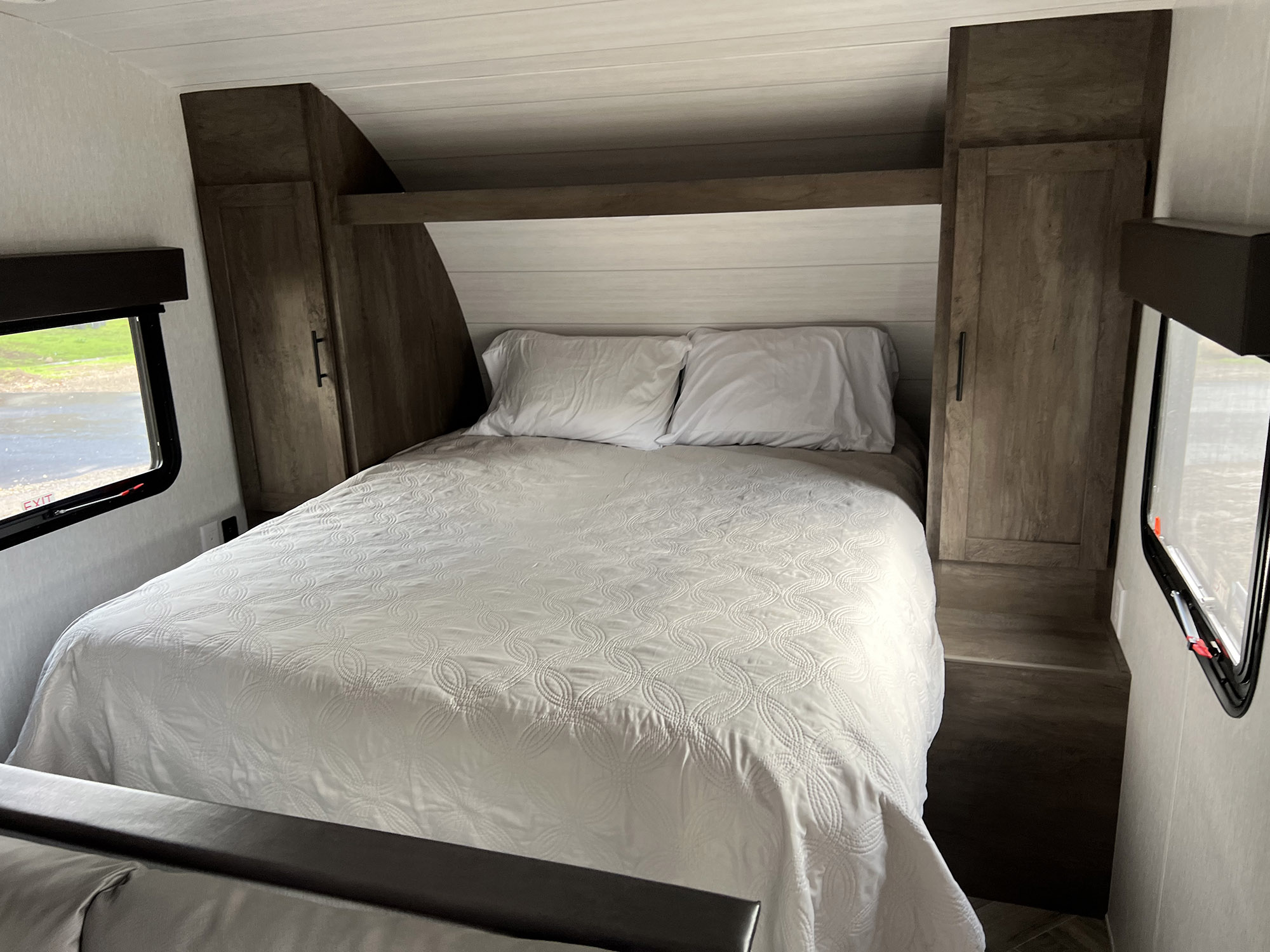 Comfortable RV rental bedroom with white bedding and built-in storage units. Ready for your next adventure.. Forest River EVO Select 268 BH 2022