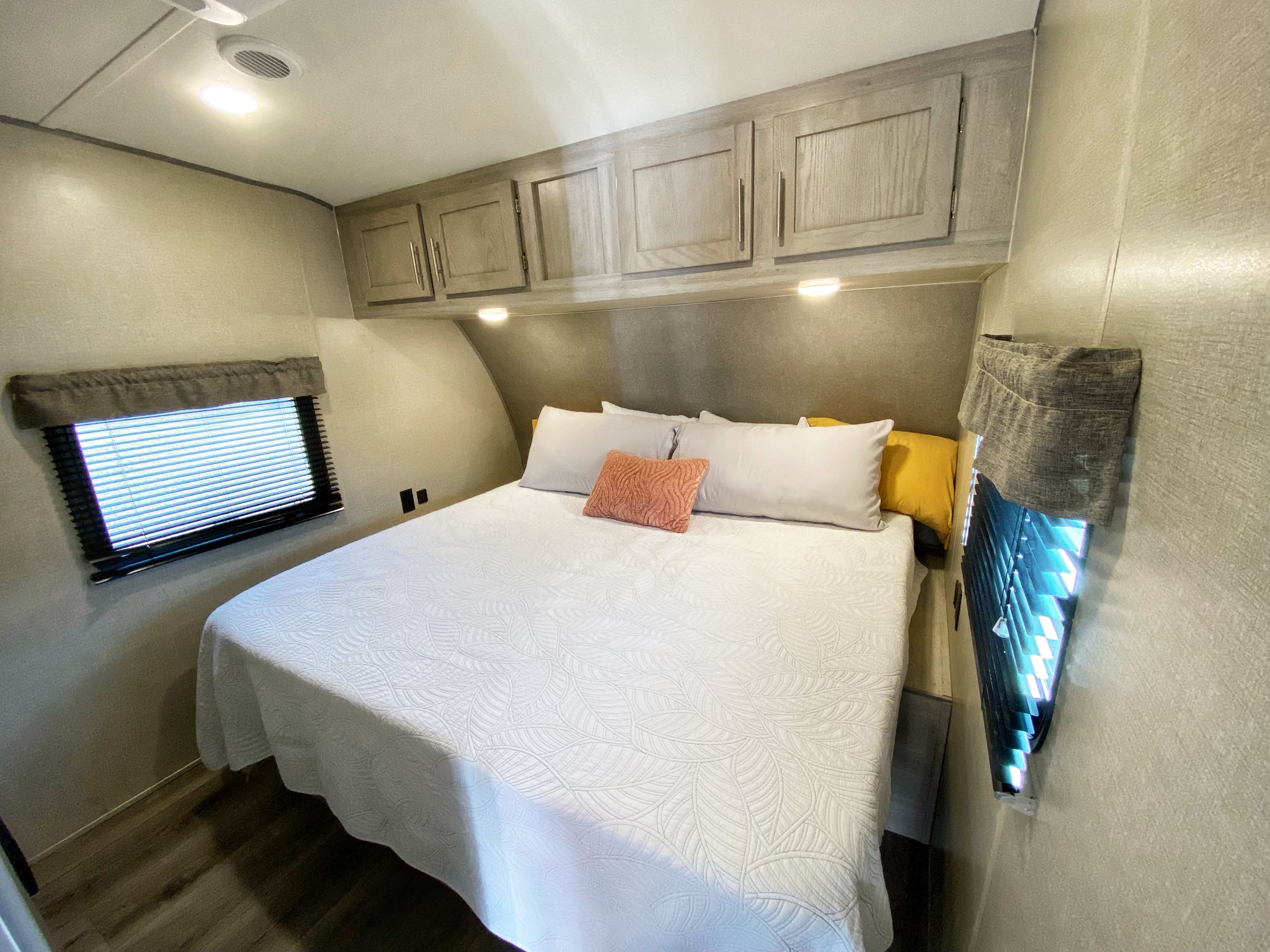 Comfortable RV rental bedroom with queen bed, overhead storage, and windows for natural light.. Coachmen Catalina 2022