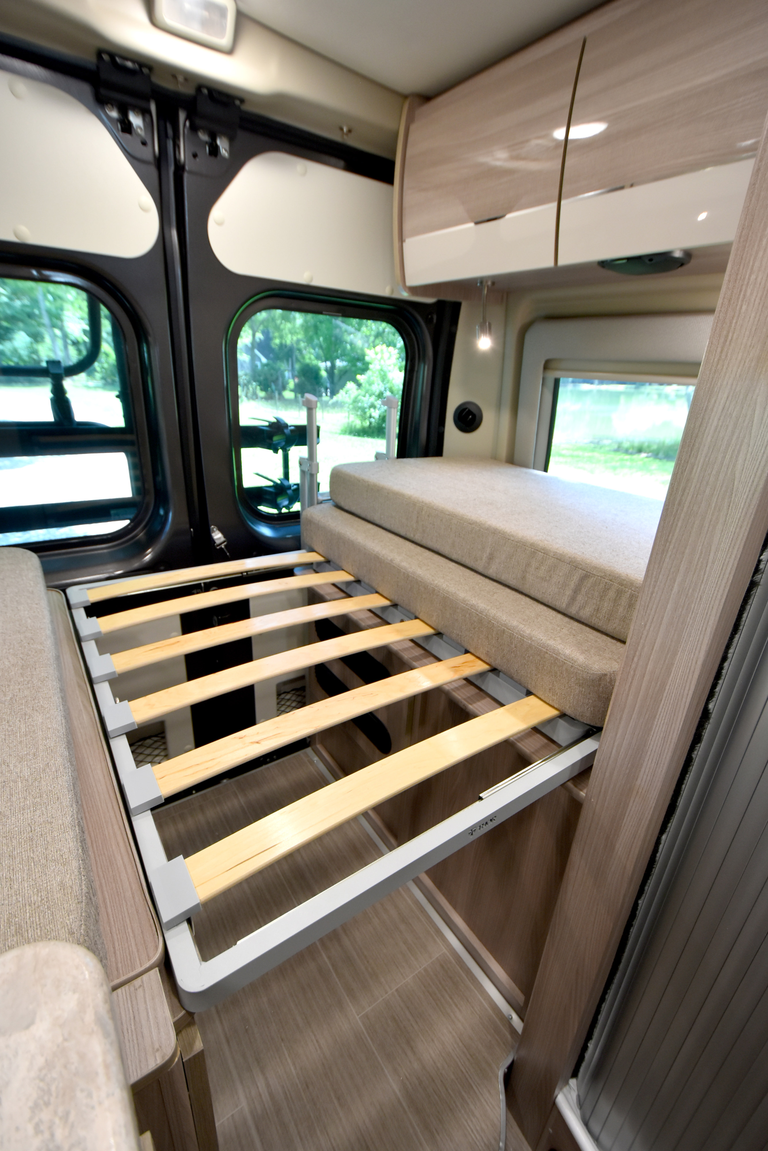 RV rental interior: Convertible bed setup with wooden slats and stacked mattresses, ideal for comfortable sleep.. Thor Motor Coach Scope #9173 2023
