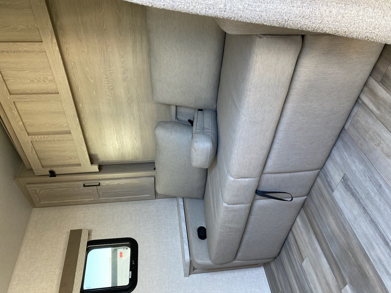 RV rental interior: Light wood cabinets & flooring complement comfy grey seating. Window view.. Flagstaff Microlite 2023