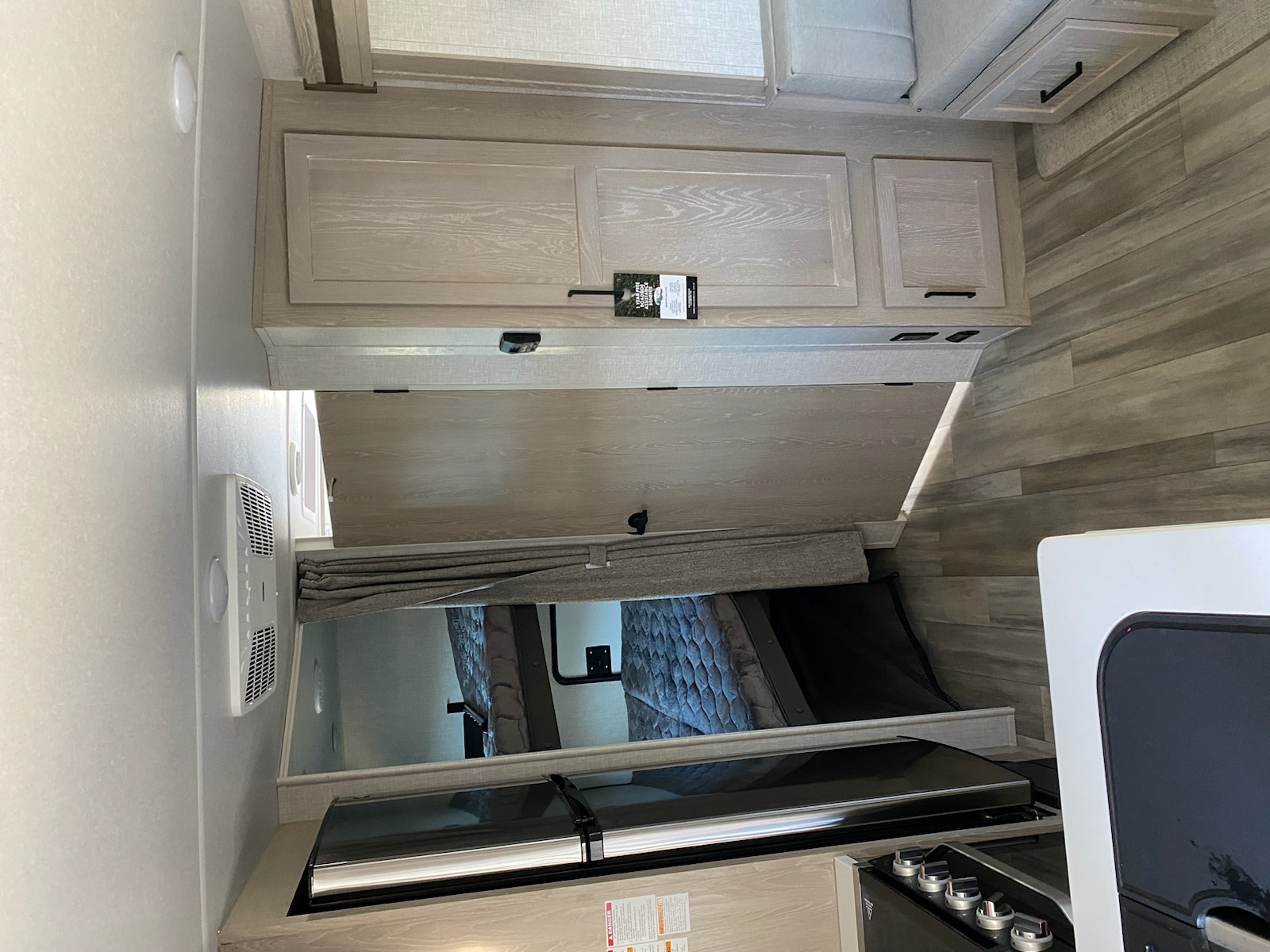 Spacious RV rental interior with modern bunk beds, overhead cabinets, and a compact kitchen area.. Flagstaff Microlite 2023