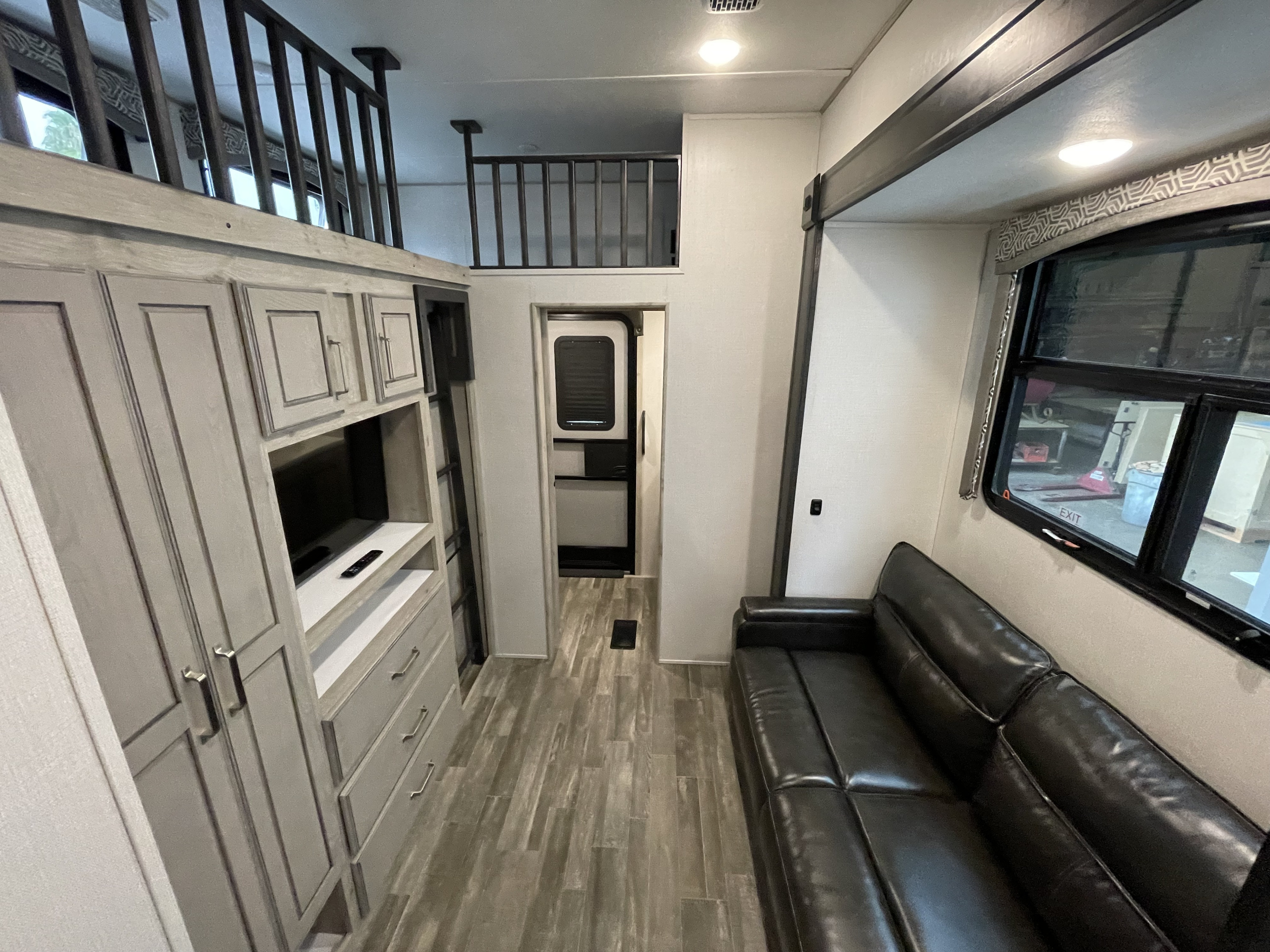 Explore this stylish RV rental! Spacious interior with sofa, TV console, storage cabinets, and an inviting overhead loft.. Keystone RV Avalanche 2021