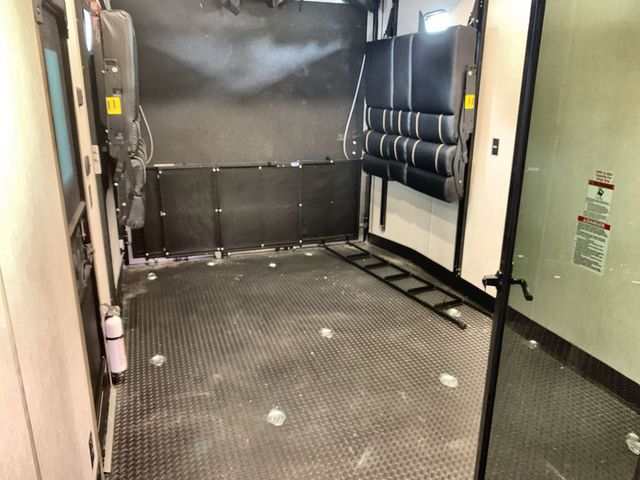 Spacious RV rental toy hauler garage with versatile seating/beds, tie-downs, and a fire extinguisher, ready for adventure.. Forest River Wolf Pack 2022