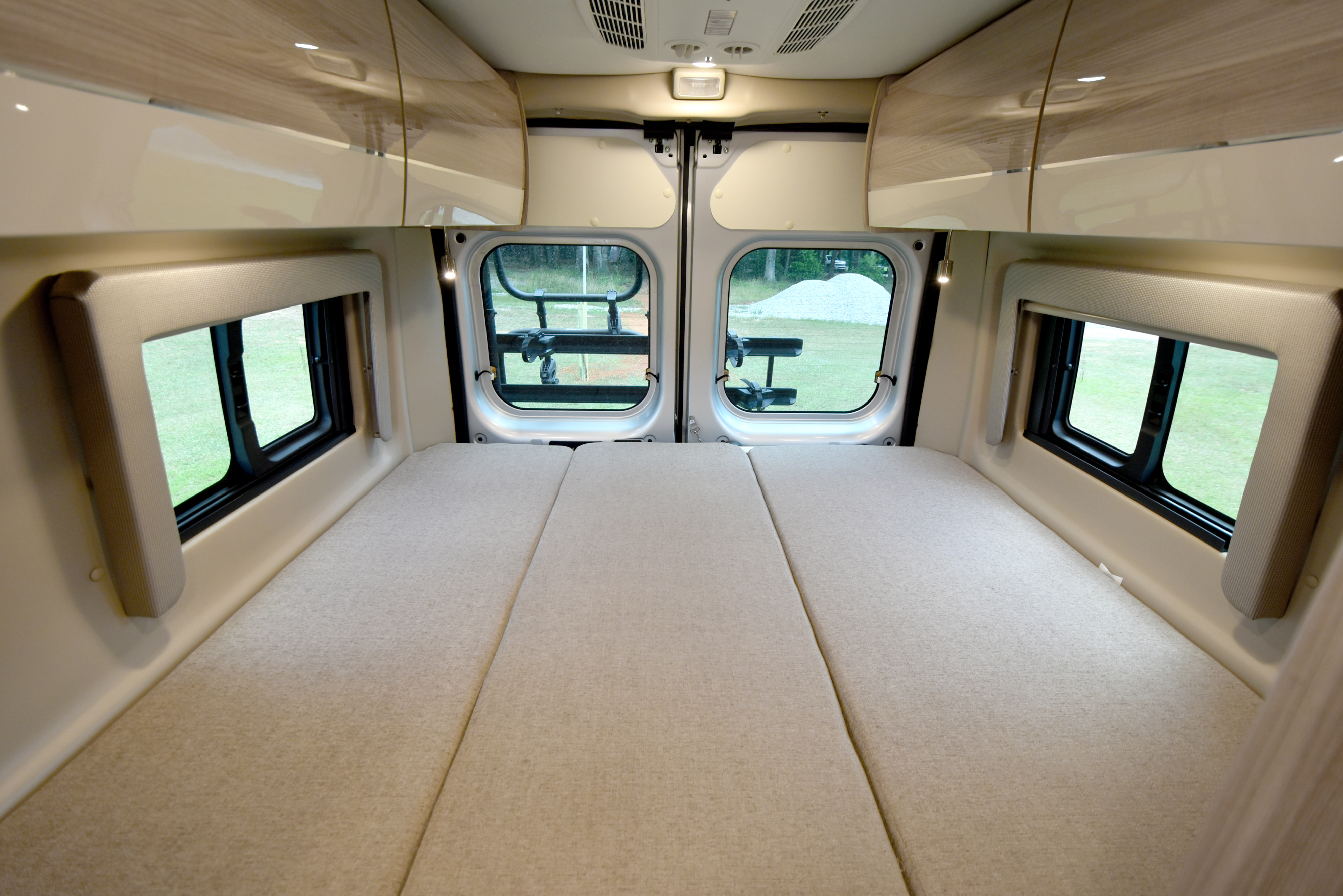 Comfortable RV rental interior featuring a large convertible bed, overhead storage, and scenic rear view windows.. Thor Motor Coach Sequence 20A 2023