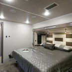 Explore comfortable travel with this spacious RV rental bedroom. Modern design, large bed, and soft lighting for your journey.. Cedar Creek Champagne 2021