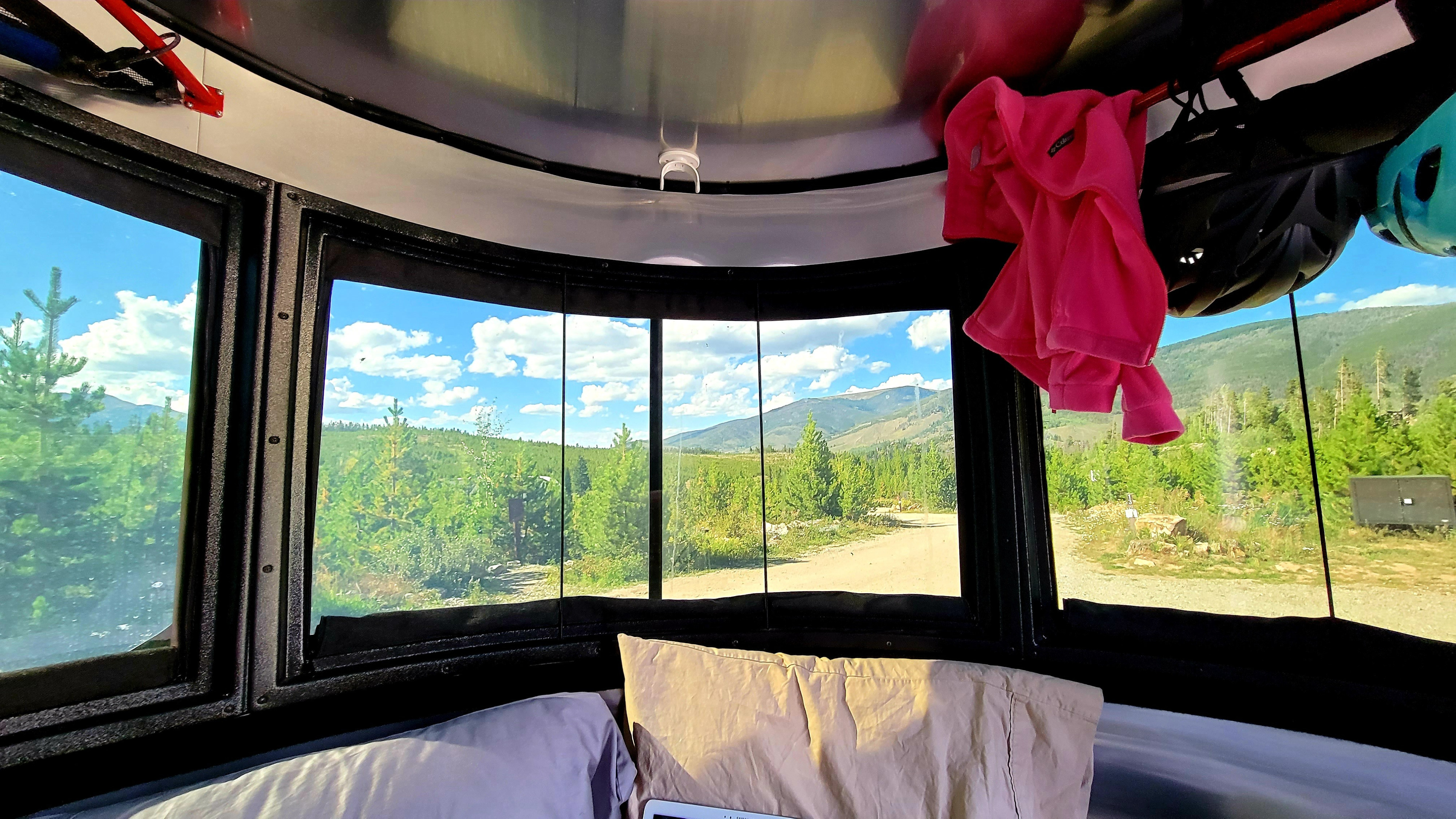 Enjoy panoramic mountain views from your cozy rv rental bed. This camper features large windows, pillows, and space for gear like helmets.. Airstream Basecamp 2021