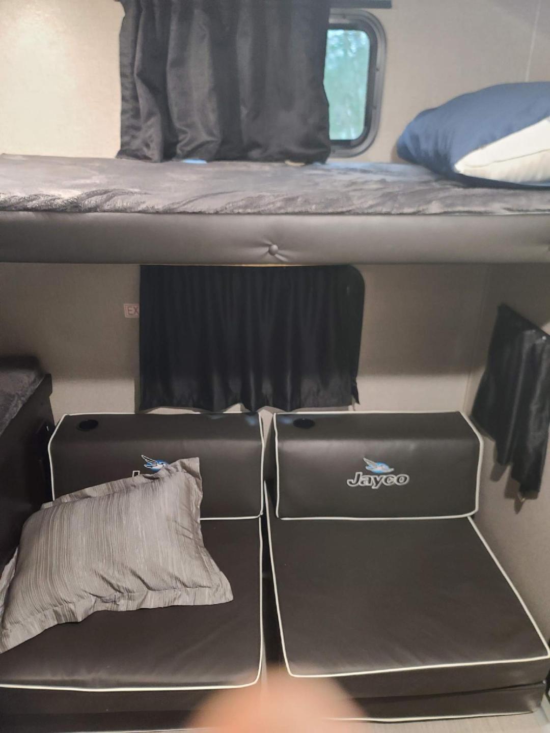 Experience comfort in your RV rental! This RV interior features sturdy bunk beds, offering ideal sleeping and lounging space.. Jayco Jay Feather 2022