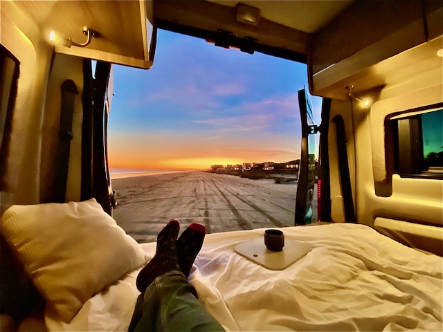 Inside a comfortable RV rental, feet up, enjoying a breathtaking beach sunset. Ideal for travel & relaxation.. Thor Motor Coach Sequence 20J 2022
